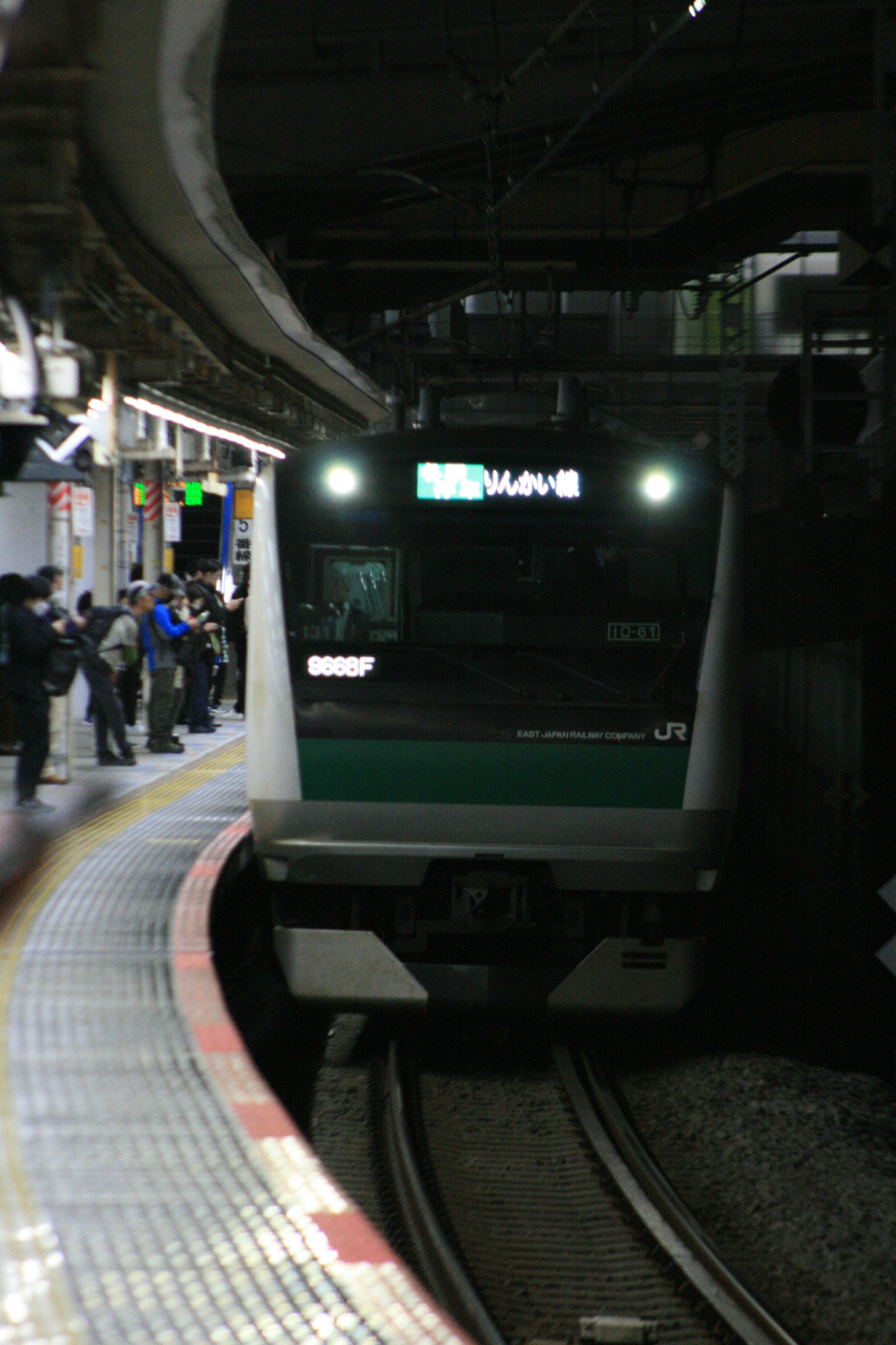 Train arriving at a dimly lit platform with visible passengers