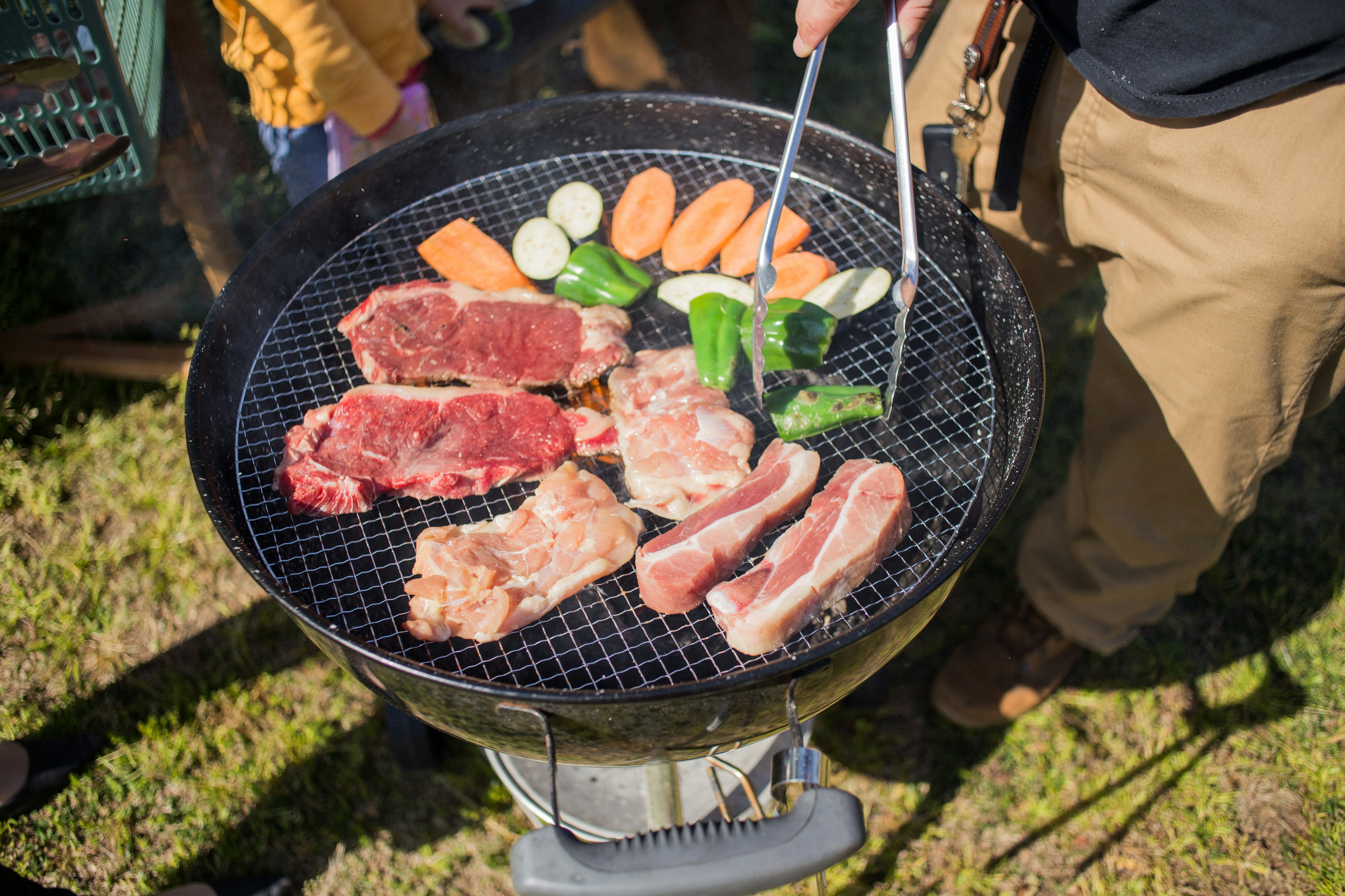 A variety of meats and vegetables grilling on a barbecue