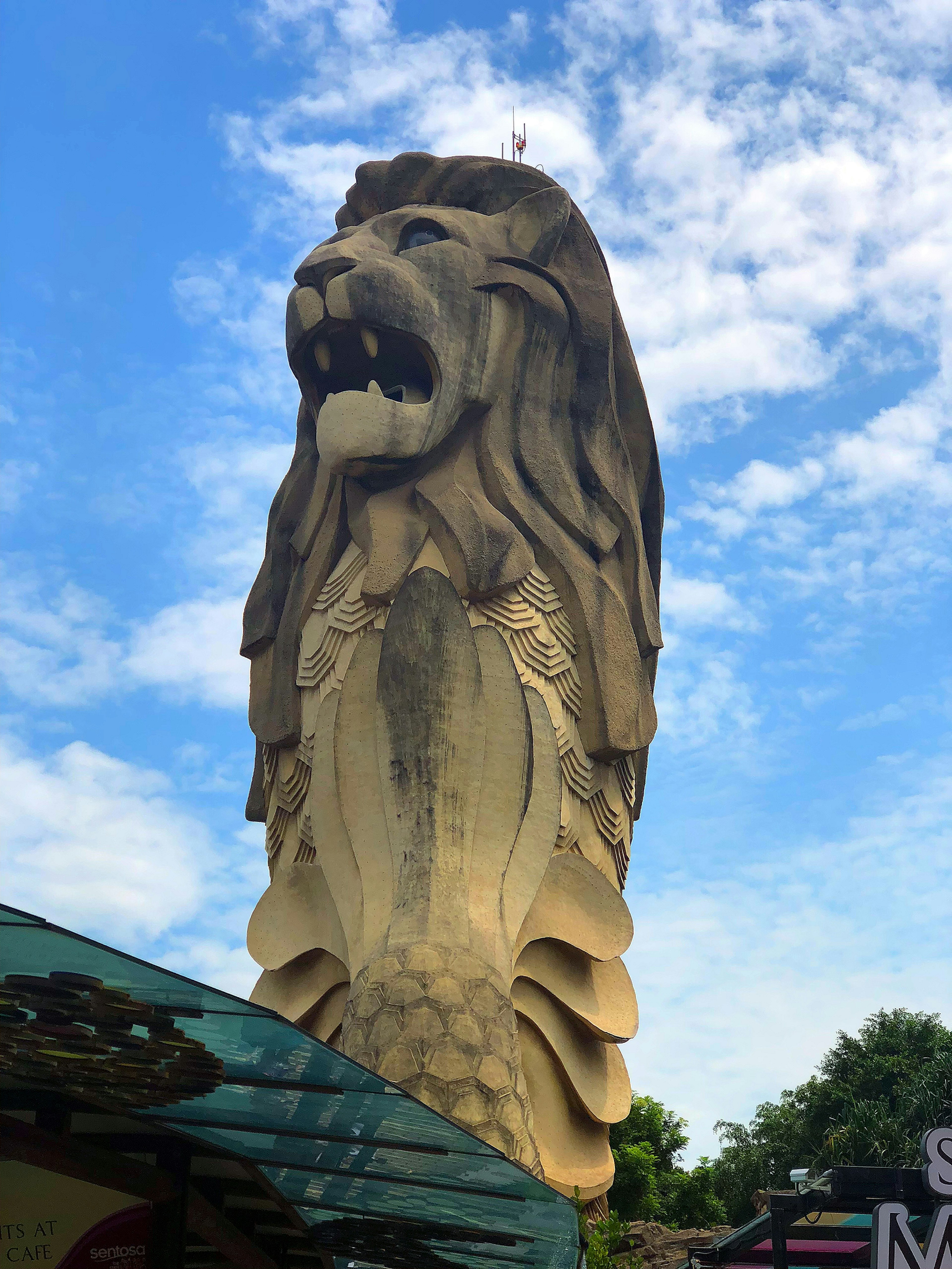 A lion statue stands under a blue sky