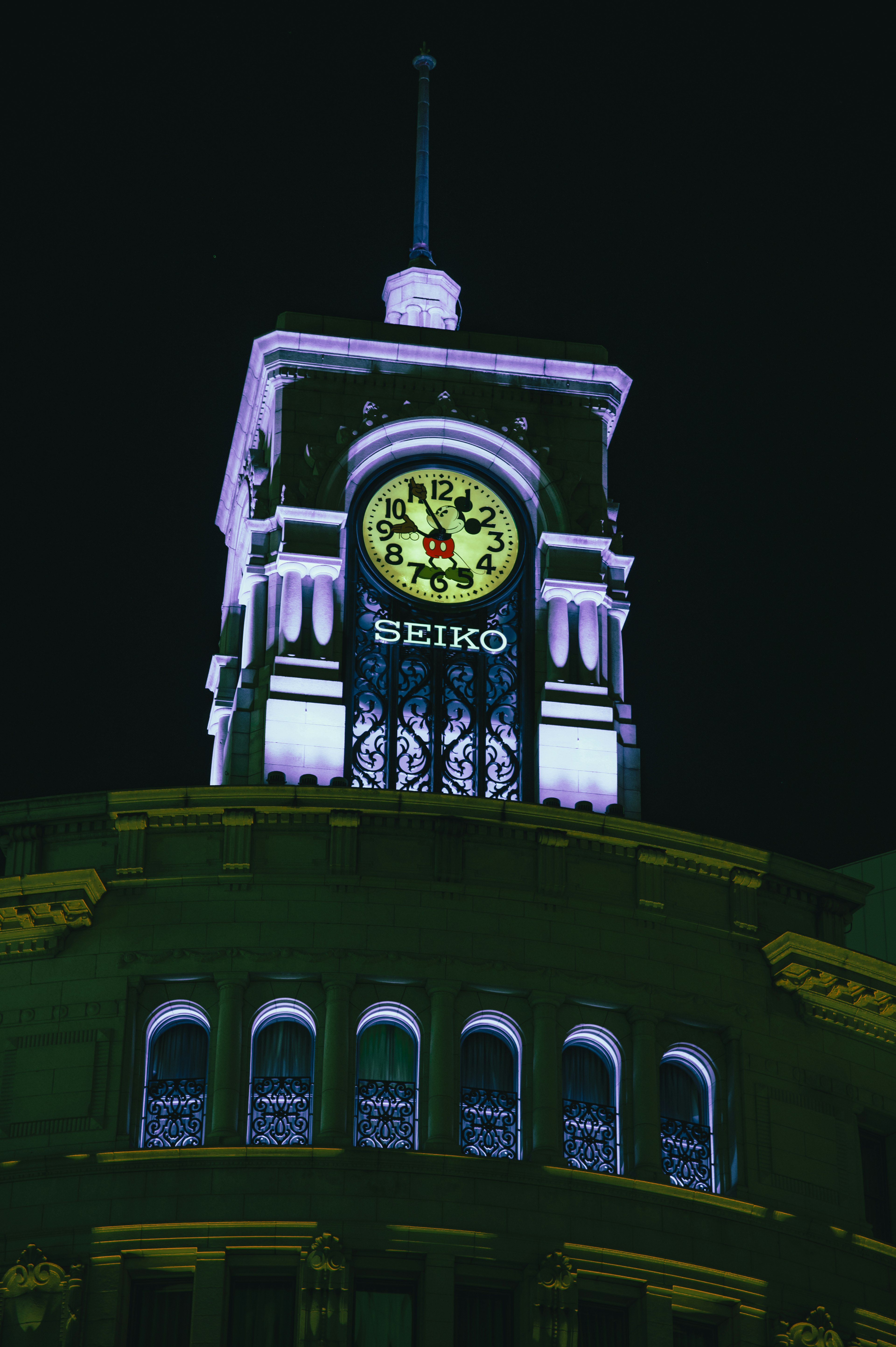 Seiko-Uhr, die nachts auf dem Dach eines Gebäudes leuchtet