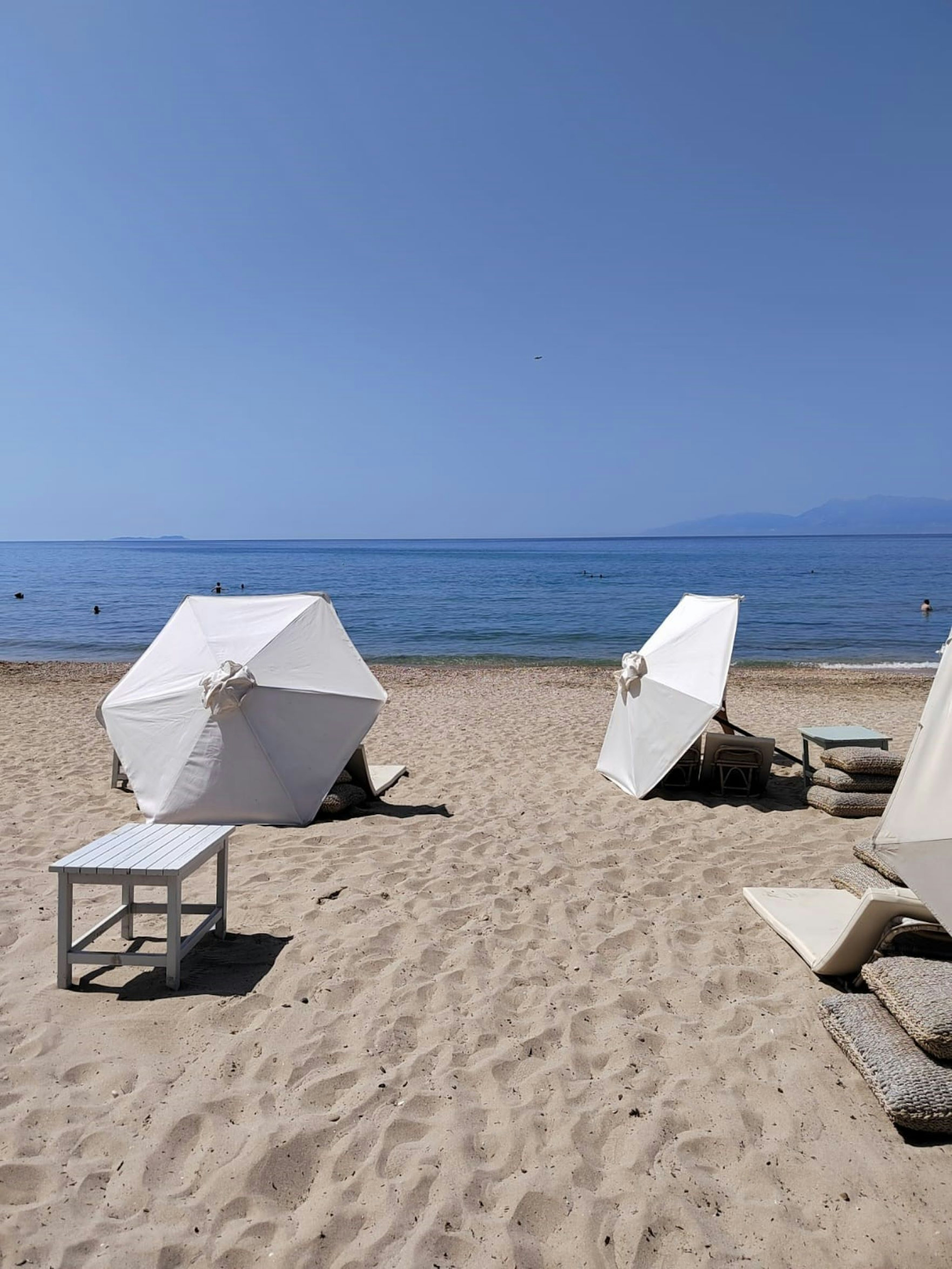 Scène de plage avec des parasols blancs et du sable