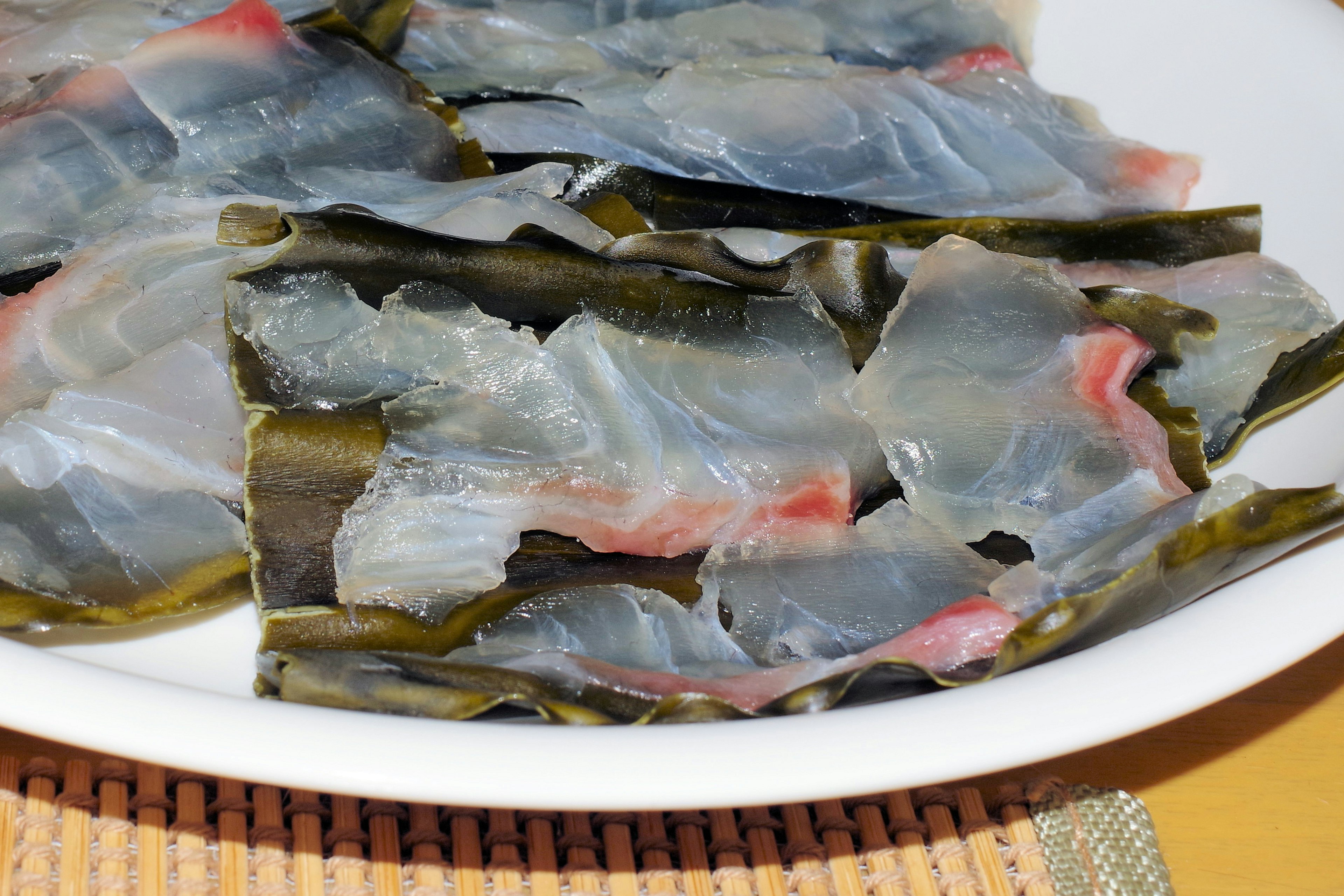 Sliced fish served on a bed of seaweed