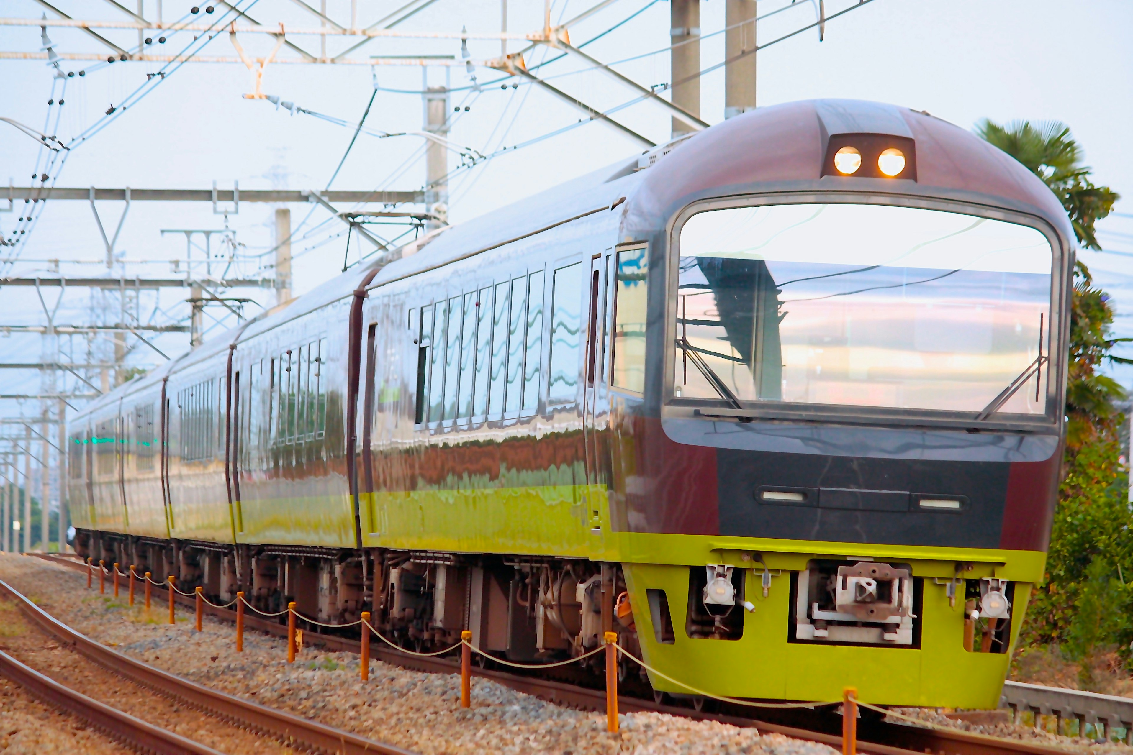 Kereta dengan fitur hijau dan merah yang melaju di rel