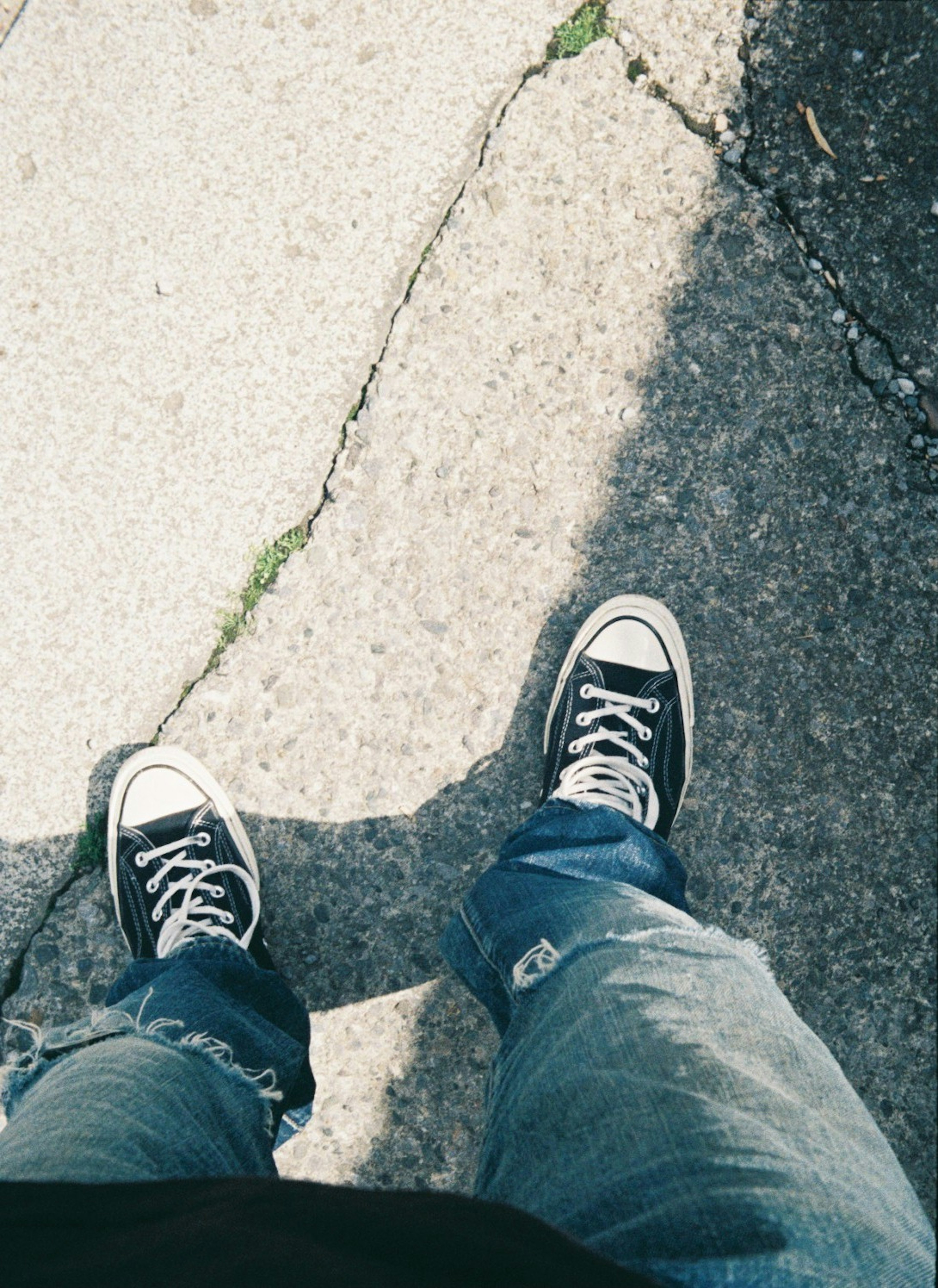 Foto von Converse-Sneakern und blauen Jeans aus der Vogelperspektive