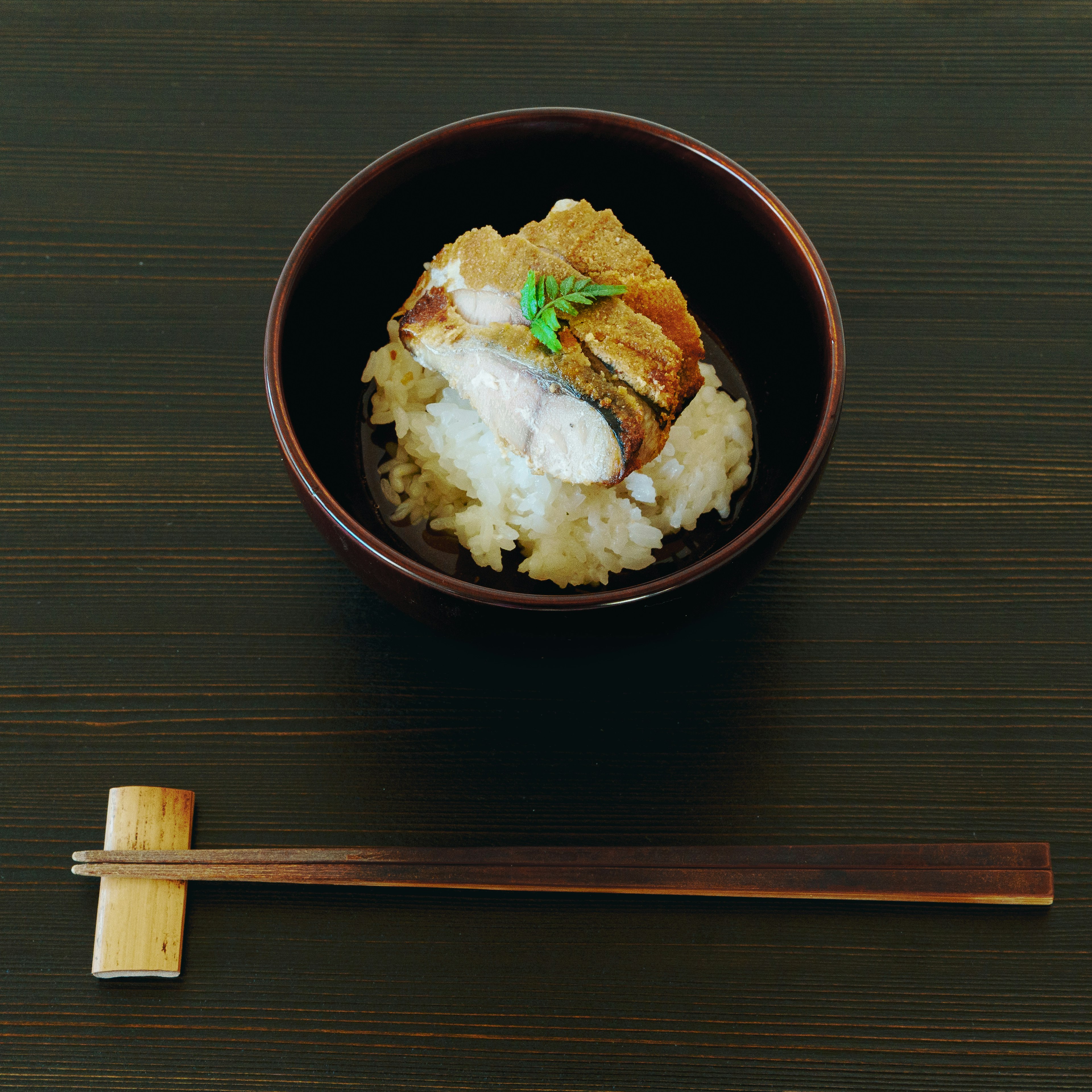 Bol de riz surmonté de poisson grillé et de garniture