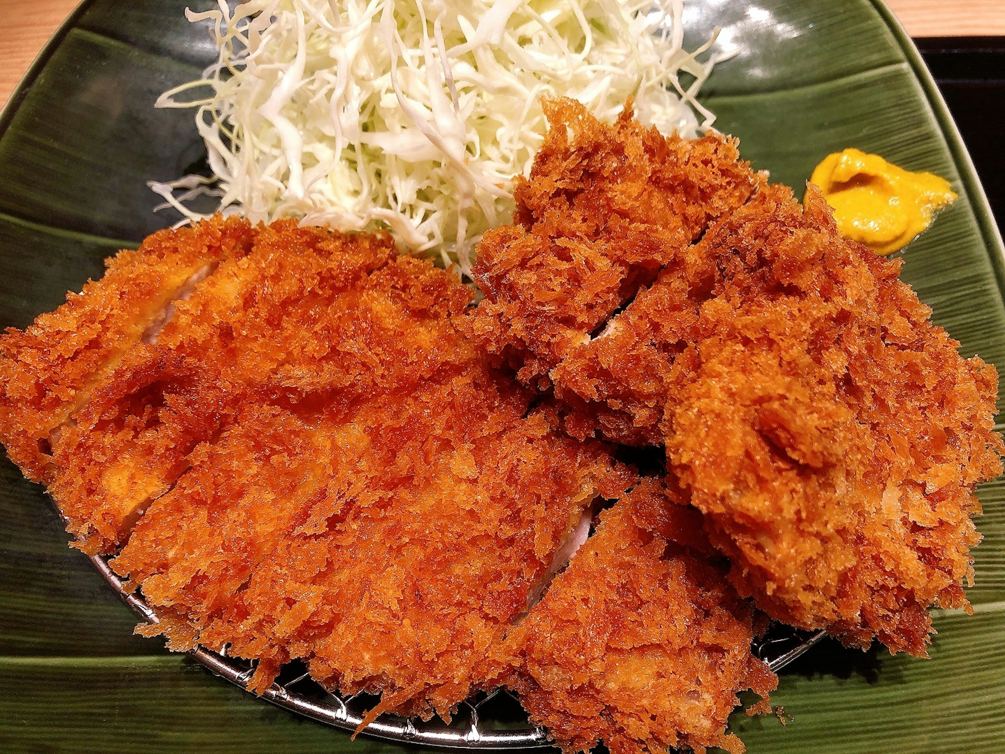 Piring berisi potongan daging goreng renyah dengan salad kol cincang