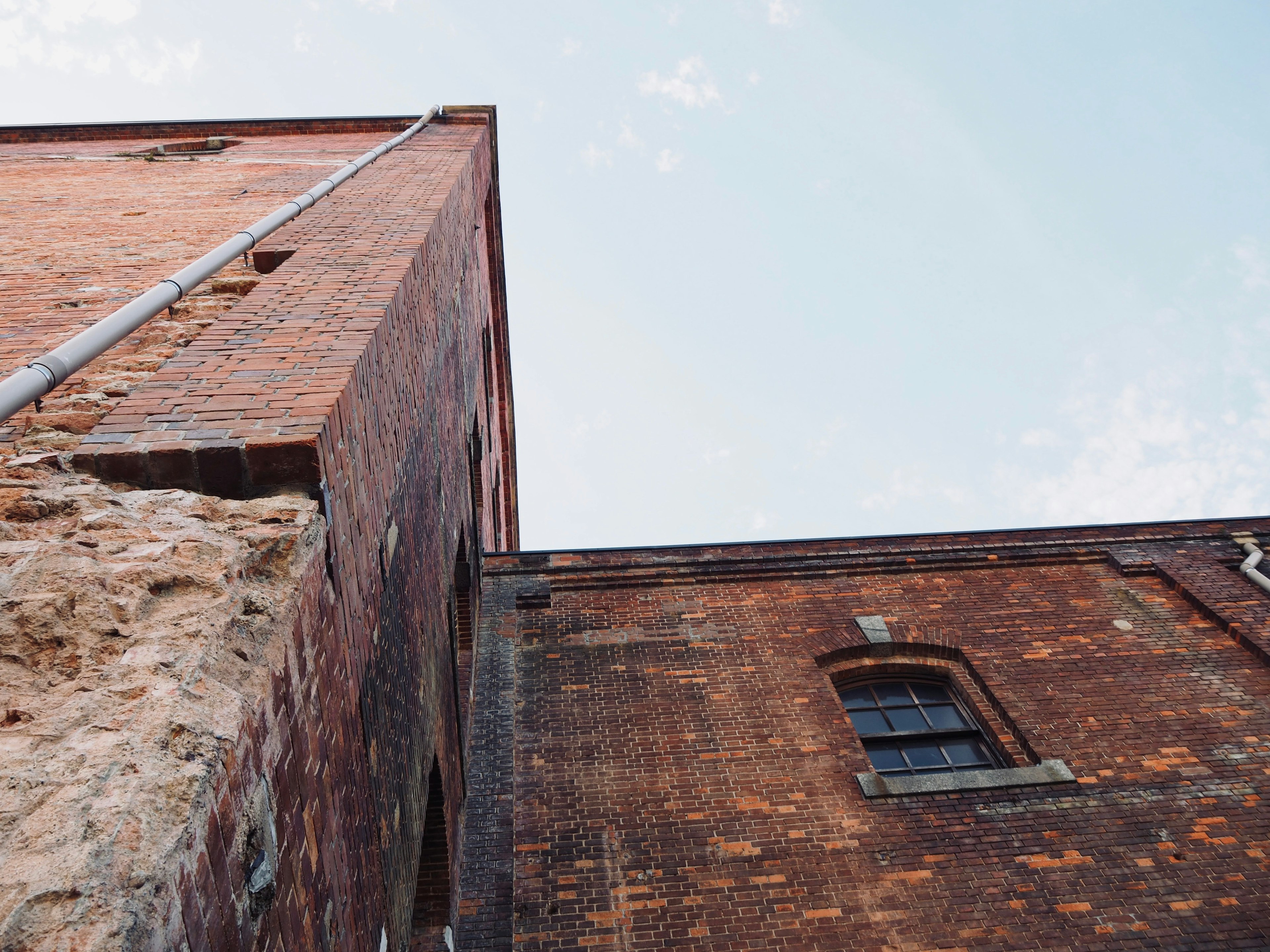 Photo looking up at an old brick building with a clear sky