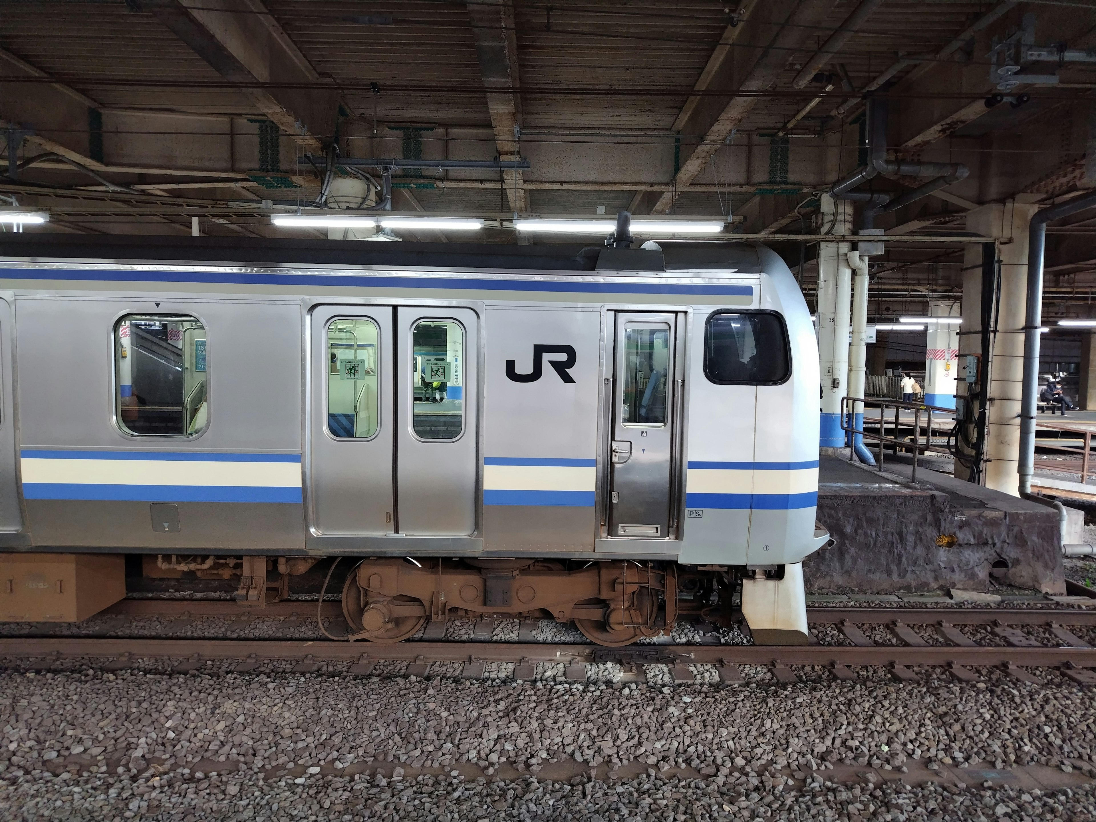 Train JR argent arrêté au quai de la gare