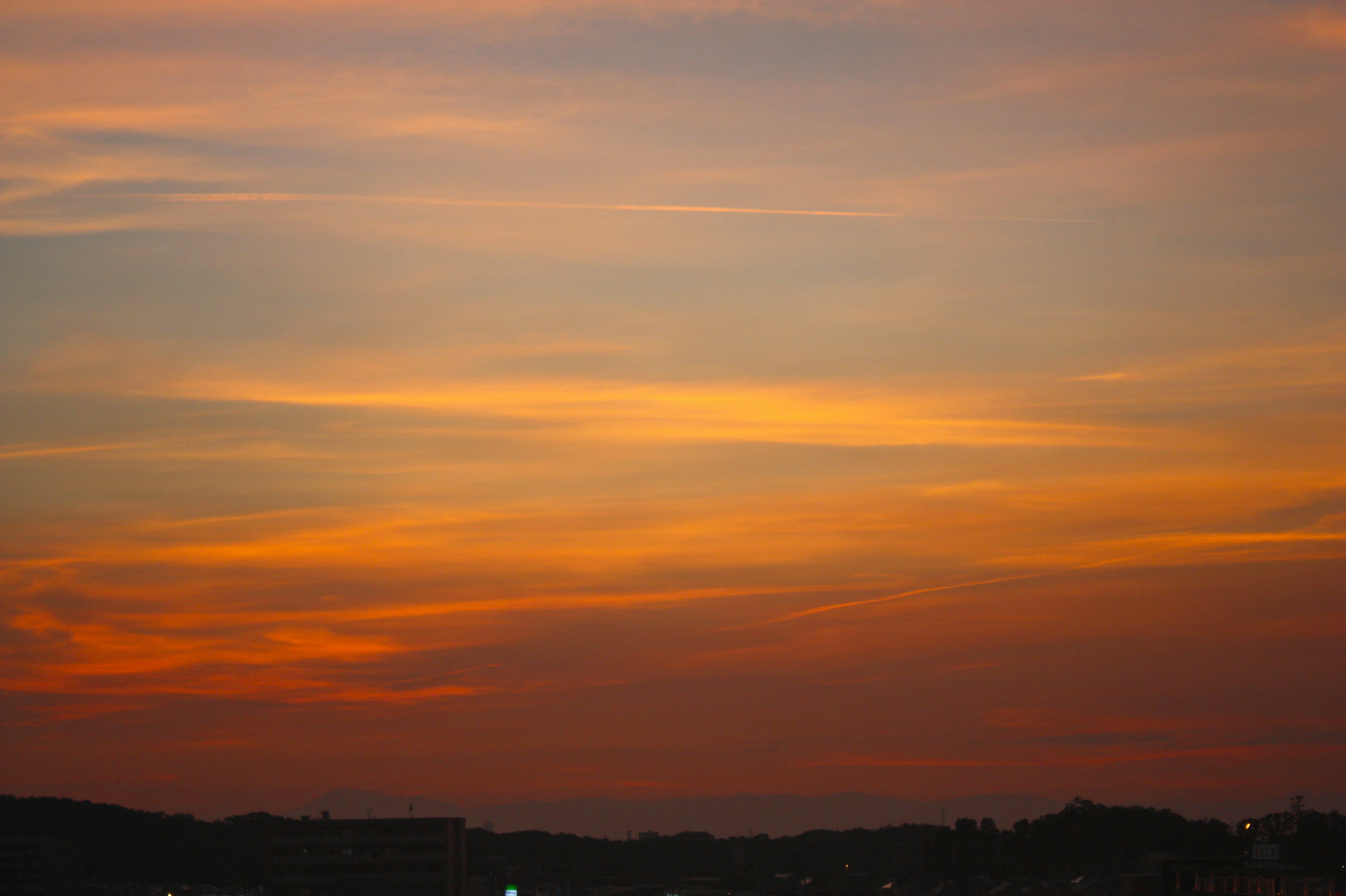 Cielo vibrante al atardecer con tonos naranjas y morados