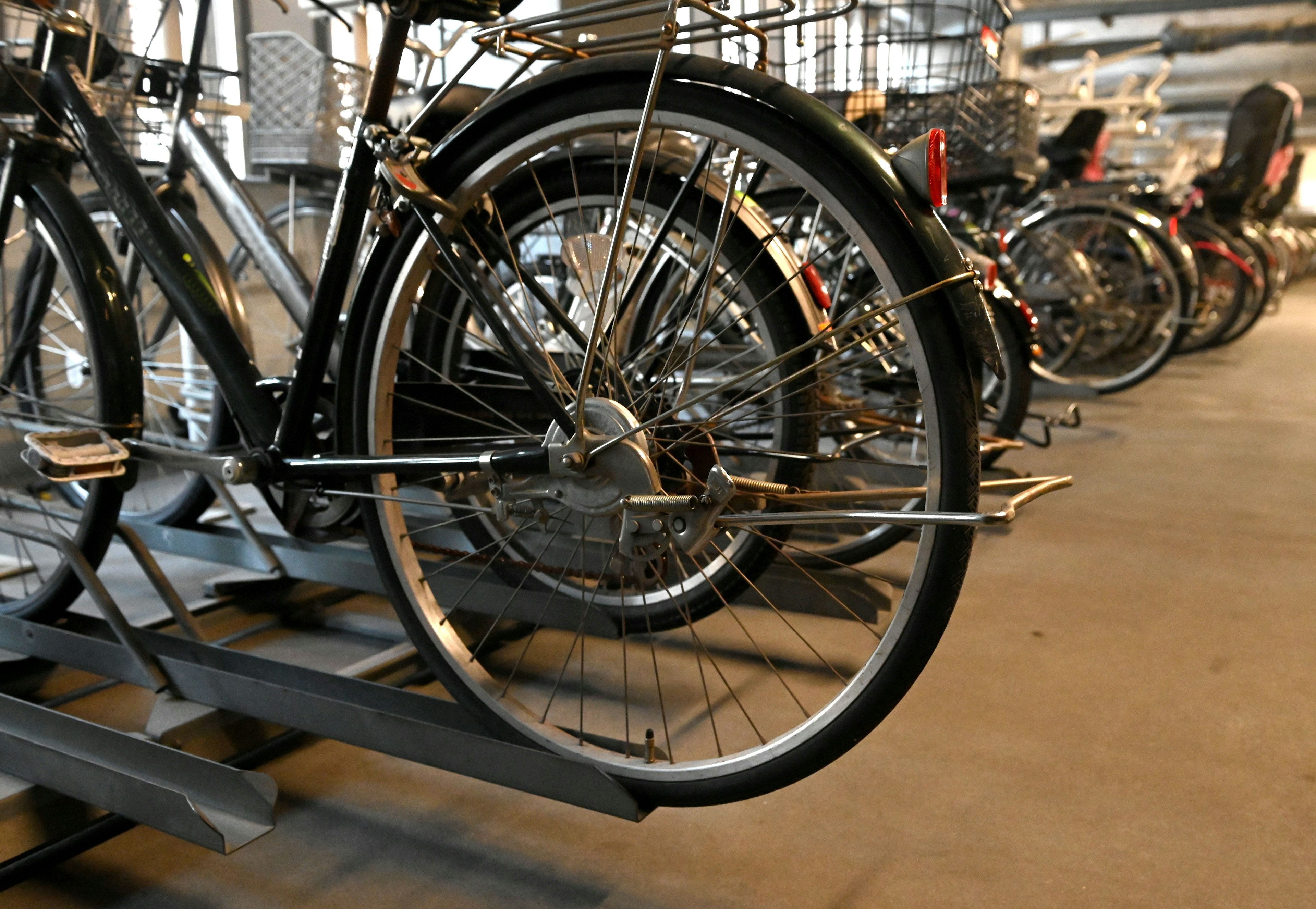 Interior view of a bike parking area with multiple bicycle wheels