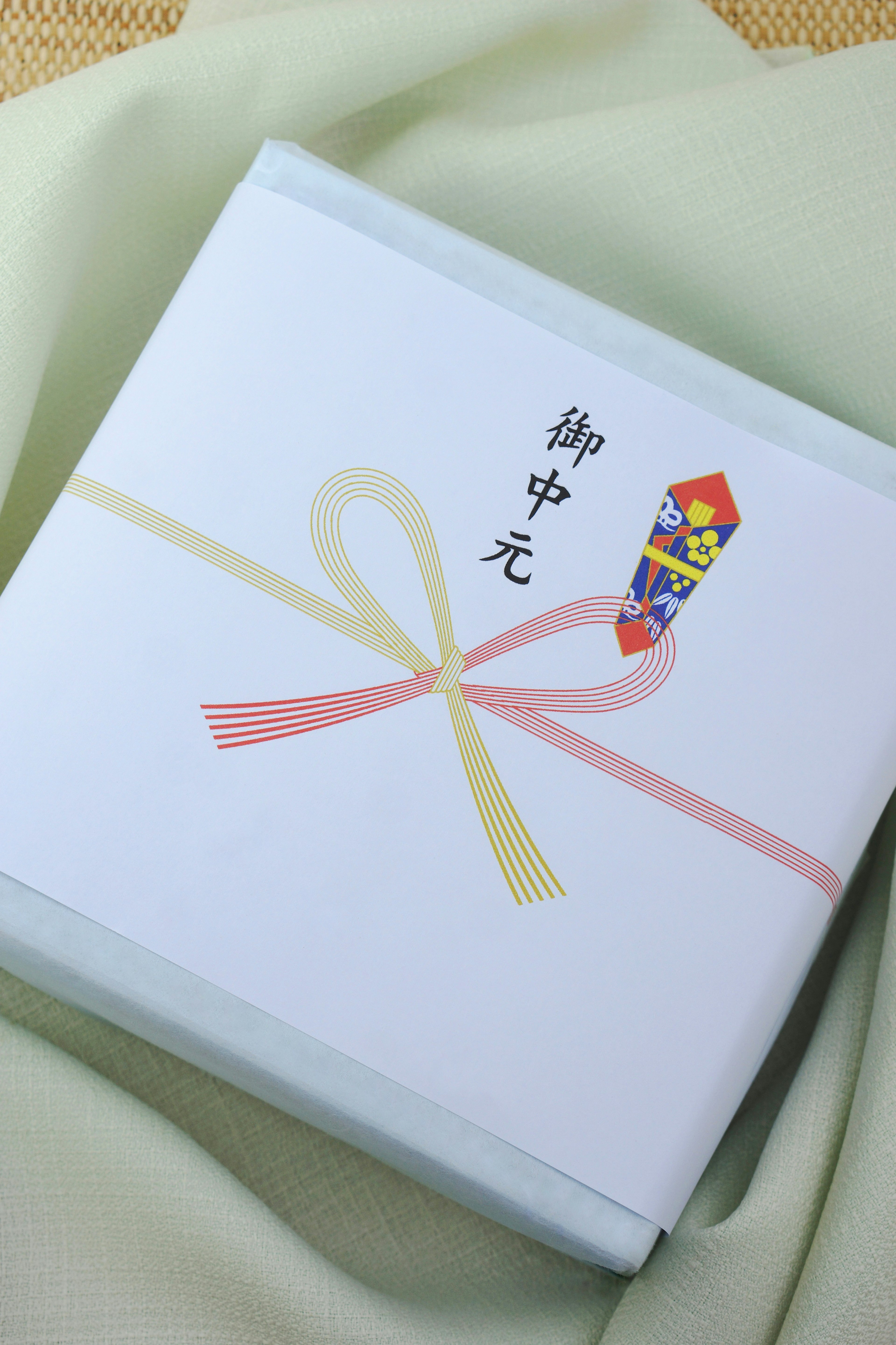 A white gift box with a ribbon and a colorful illustration on top