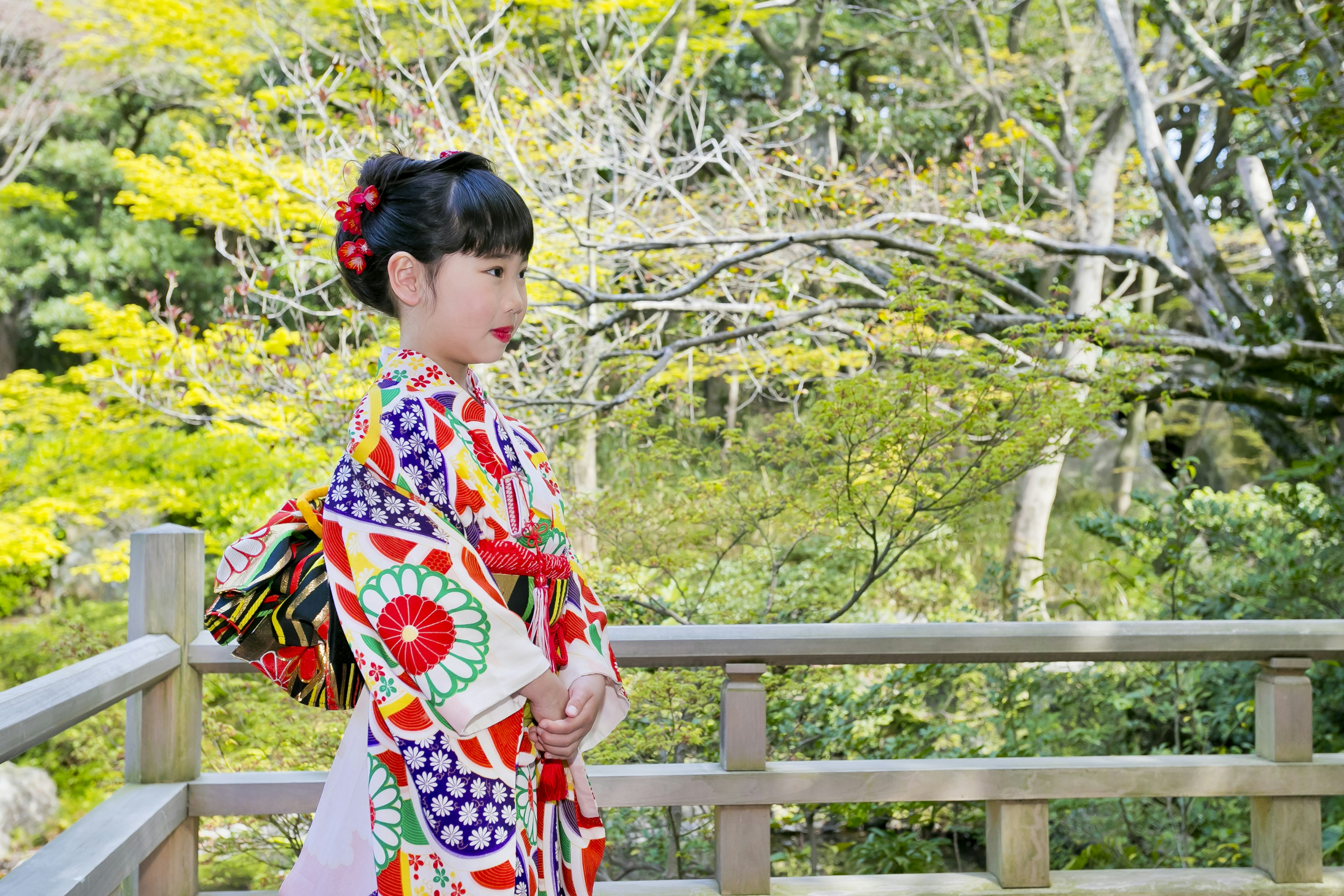 Una ragazza in un kimono colorato che sta in un ambiente naturale