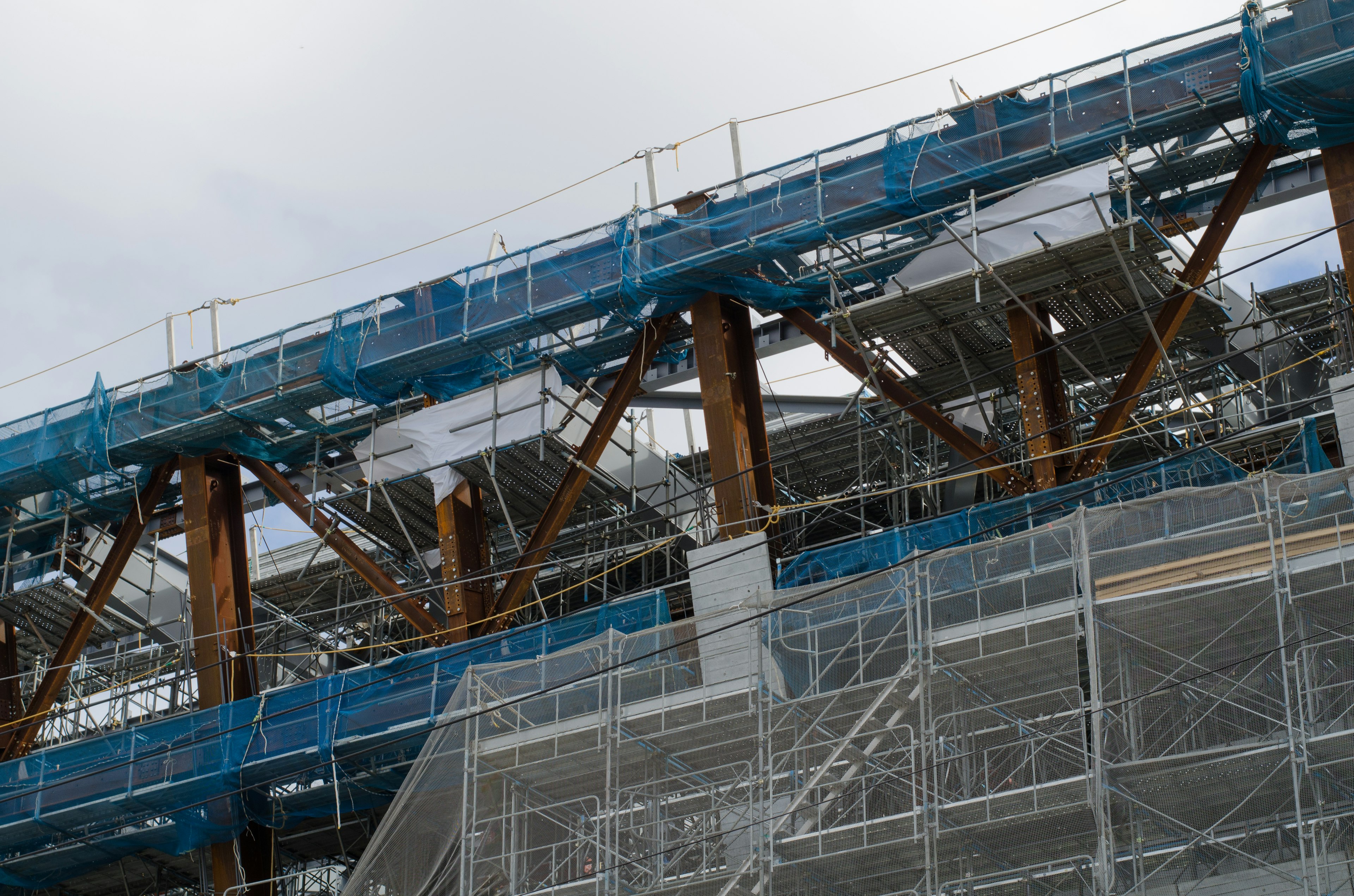 Estructura de acero y andamios azules de un edificio en construcción