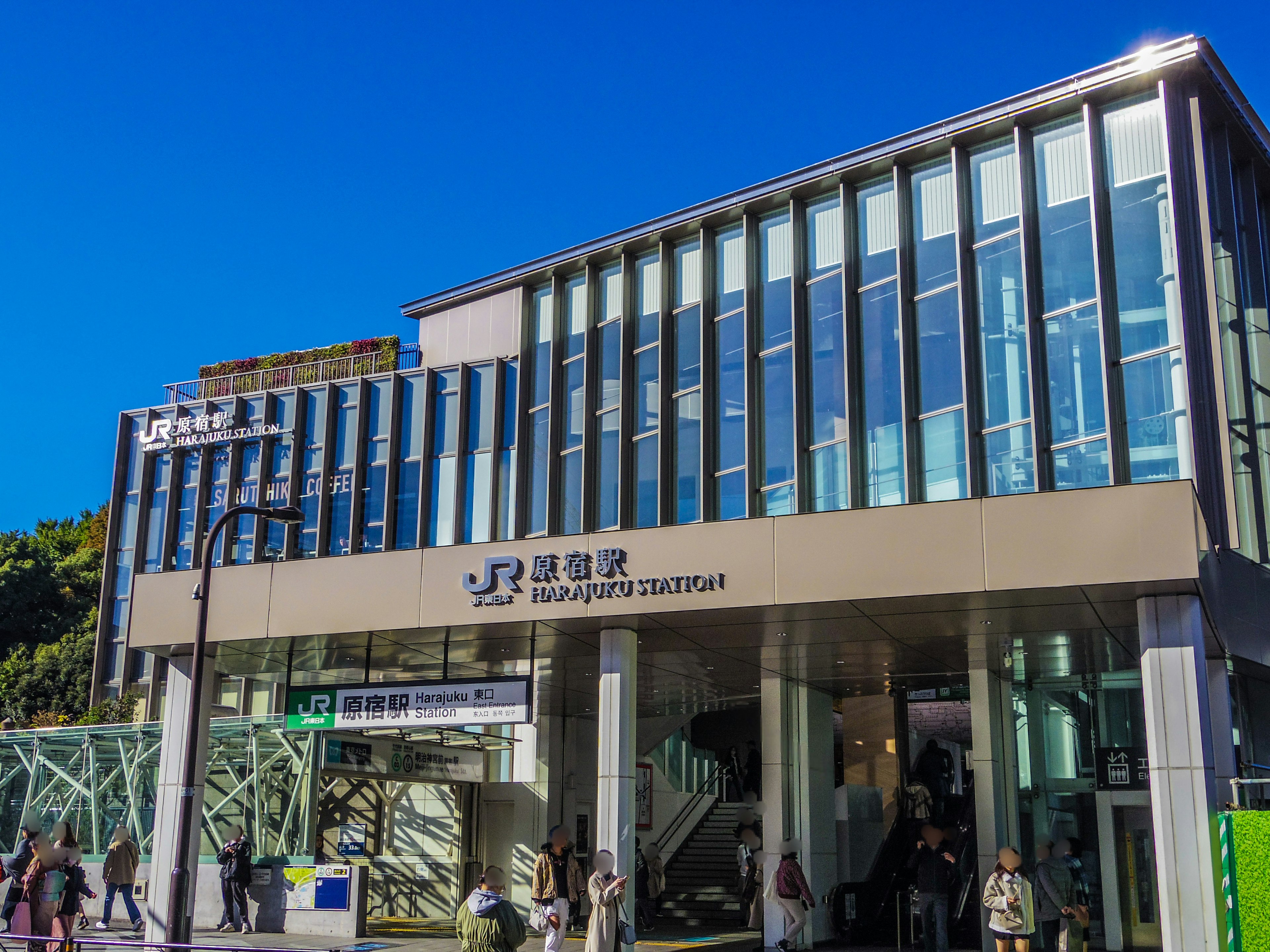 Modern exterior of JR Yamanote Line station with clear blue sky