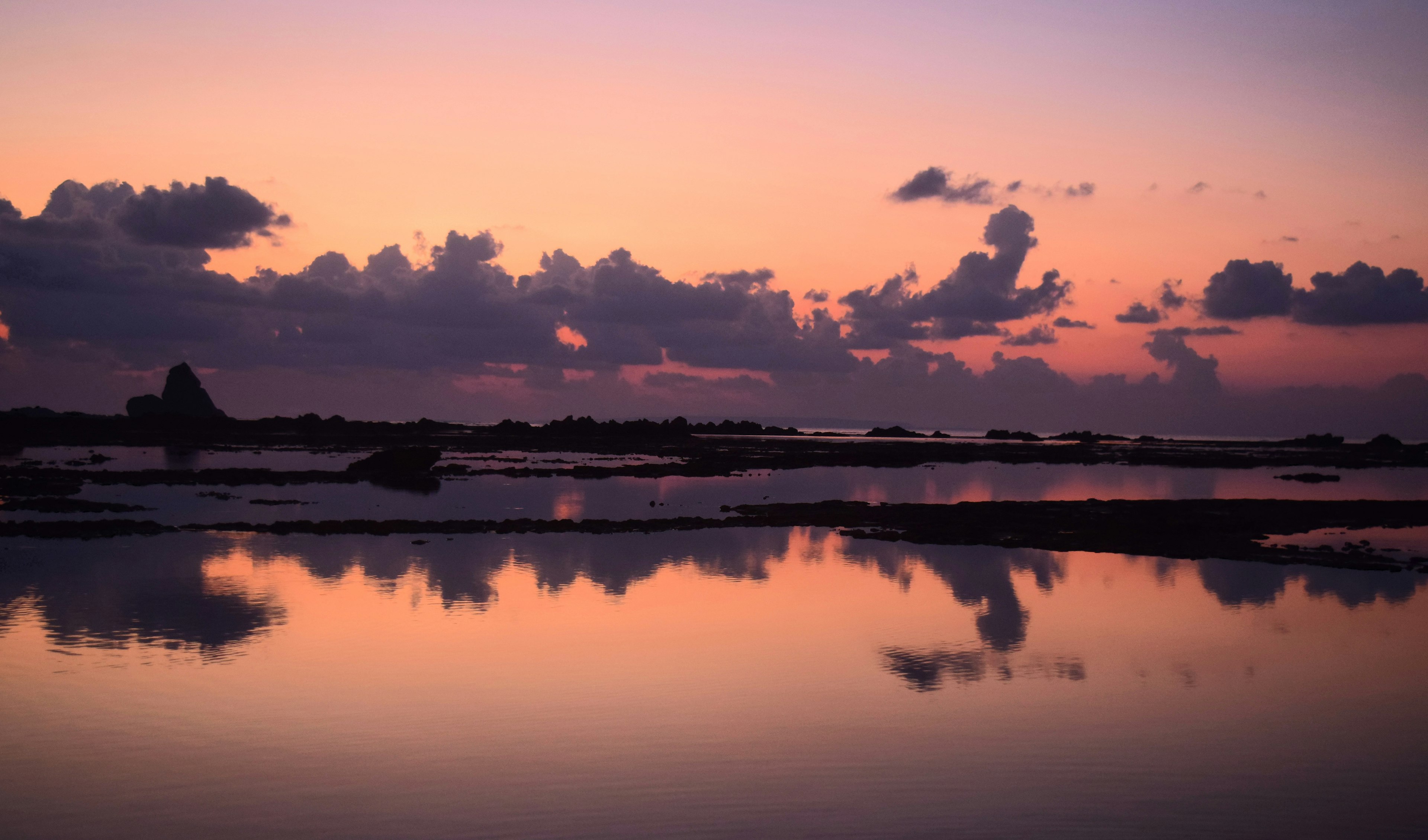 美しい夕暮れの海の景色、水面に映る色彩豊かな空と雲