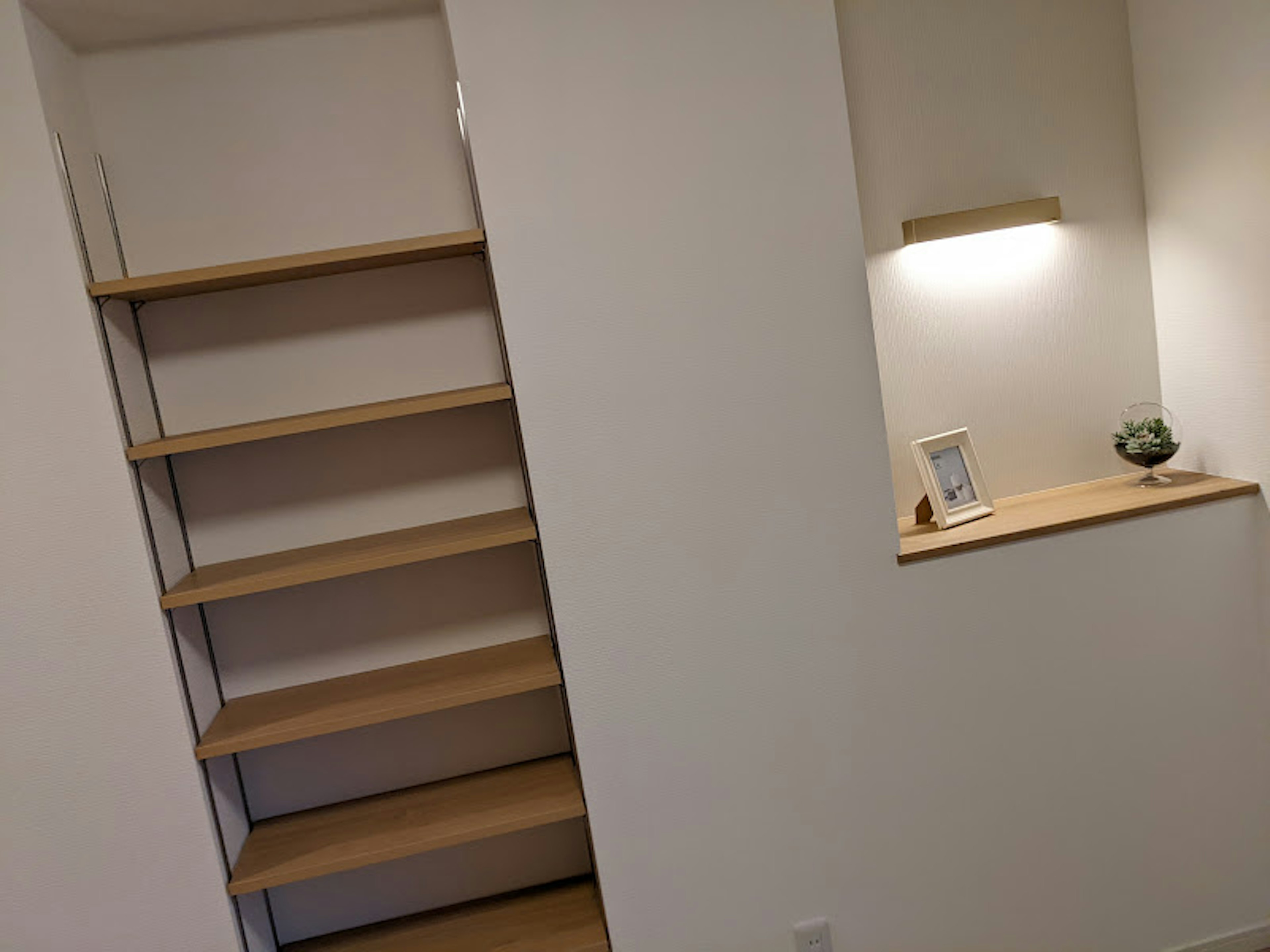 Simple wall-mounted wooden shelves with a small light fixture