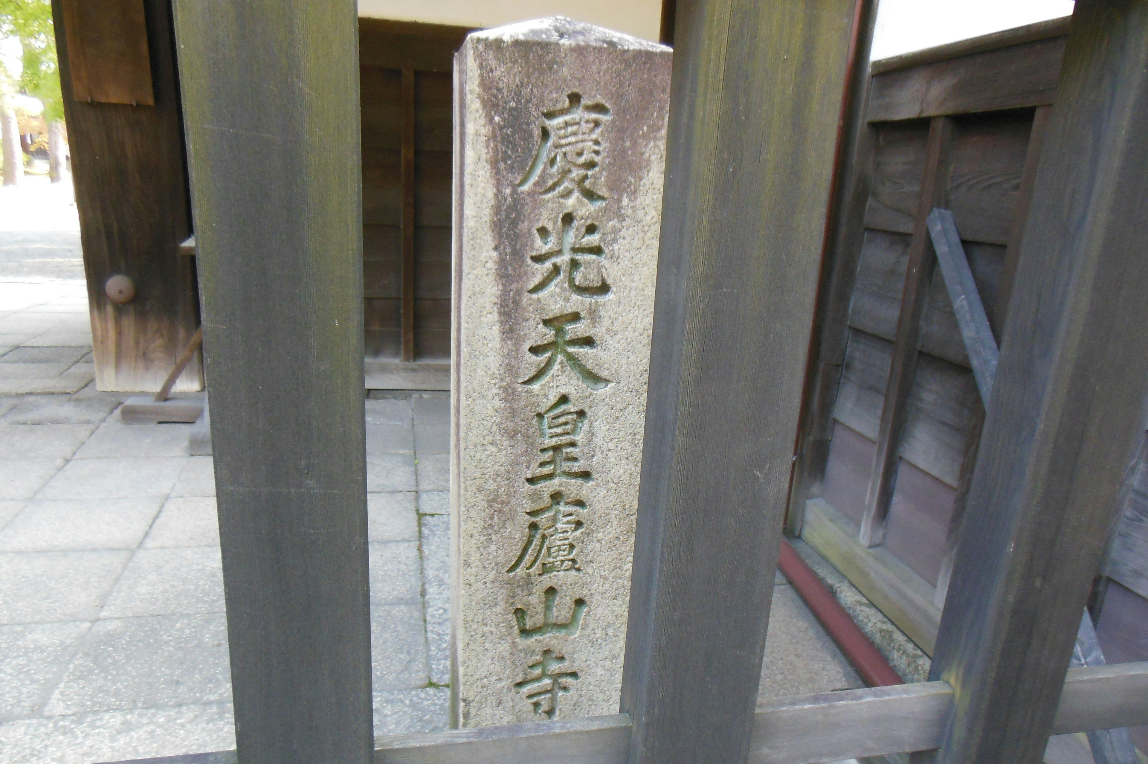 Pillar en pierre avec des caractères gravés et vue de l'entrée du temple