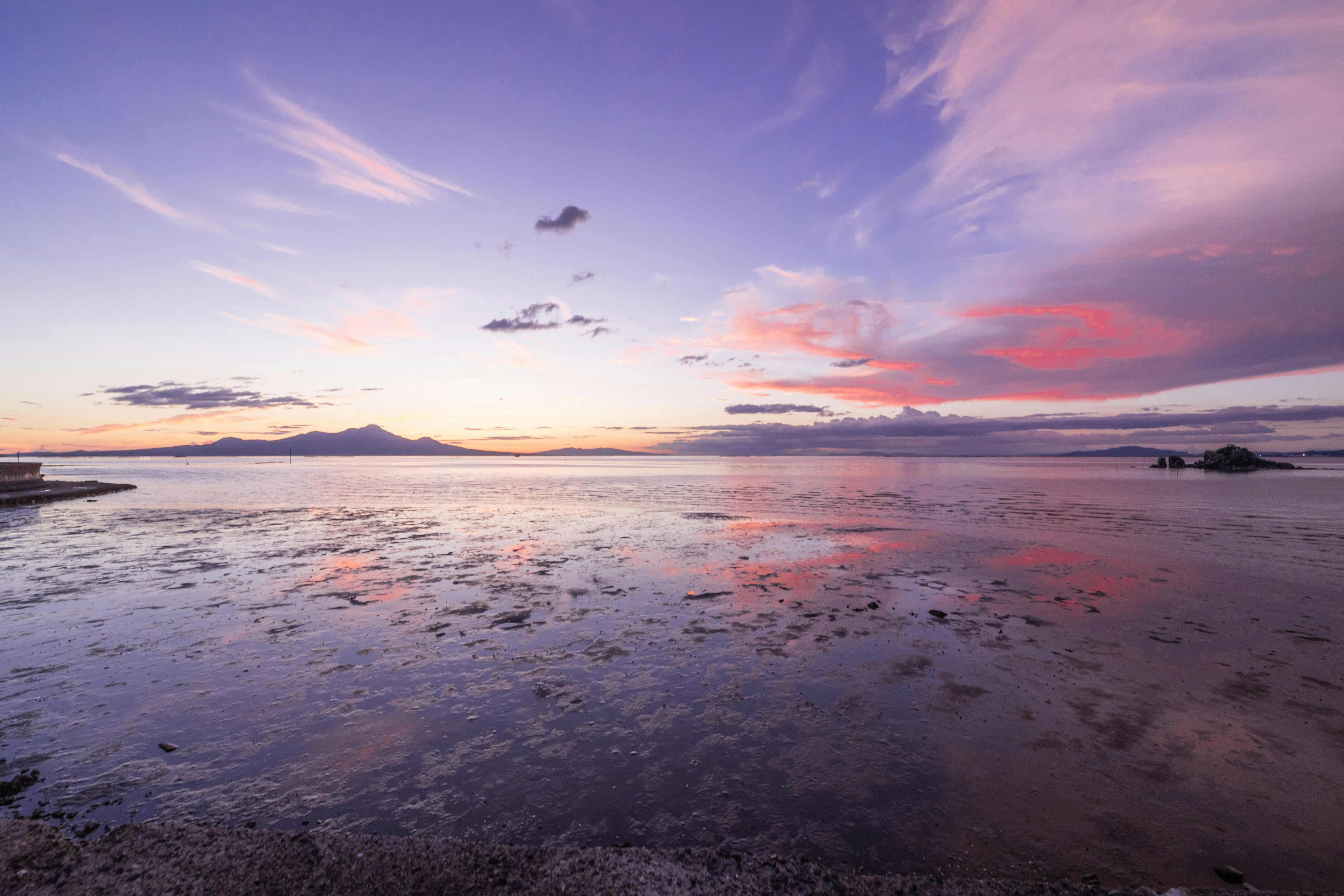 Beautiful sunset over the coastline with calm water reflecting the sky colors