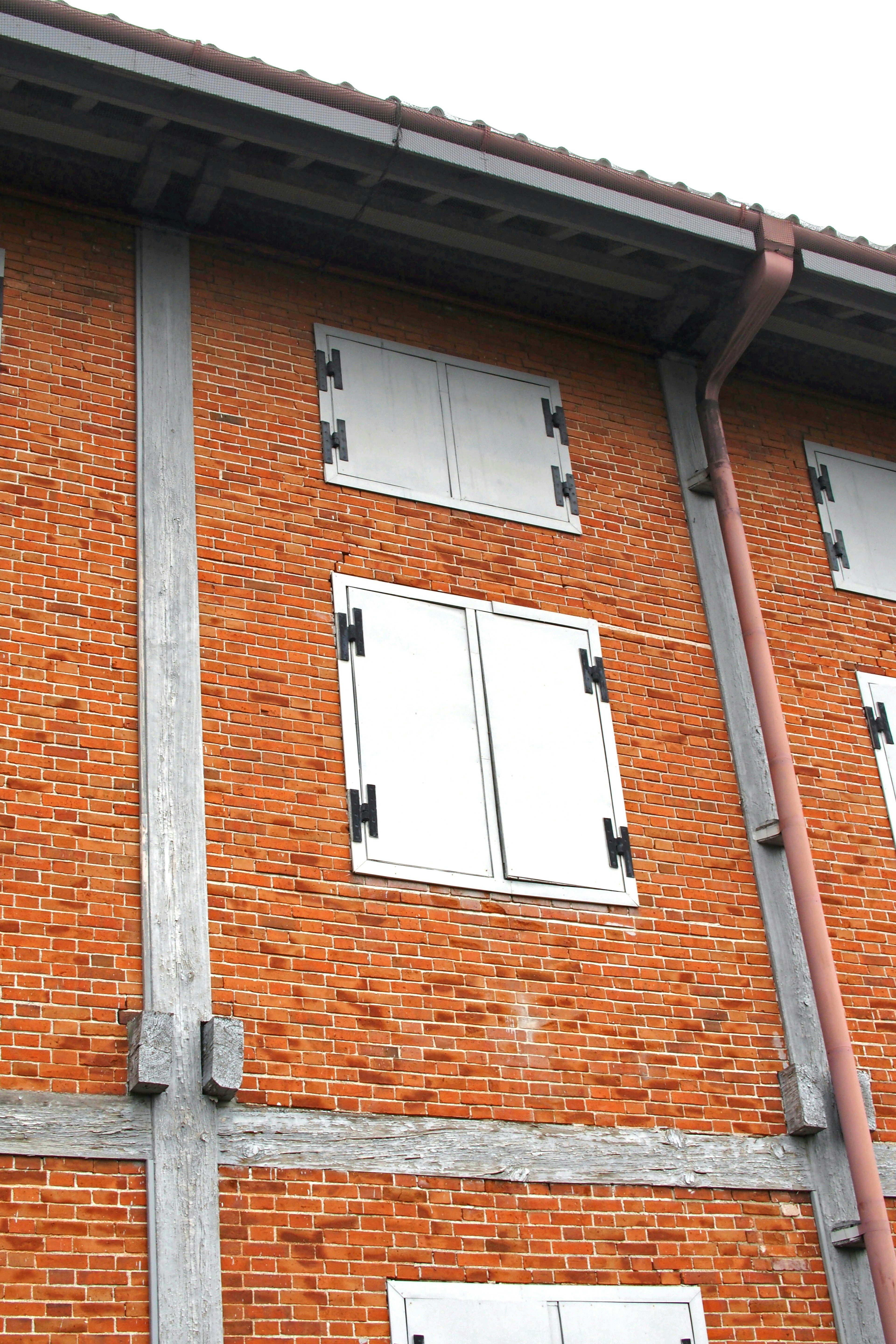 Extérieur d'un bâtiment en briques avec des volets blancs