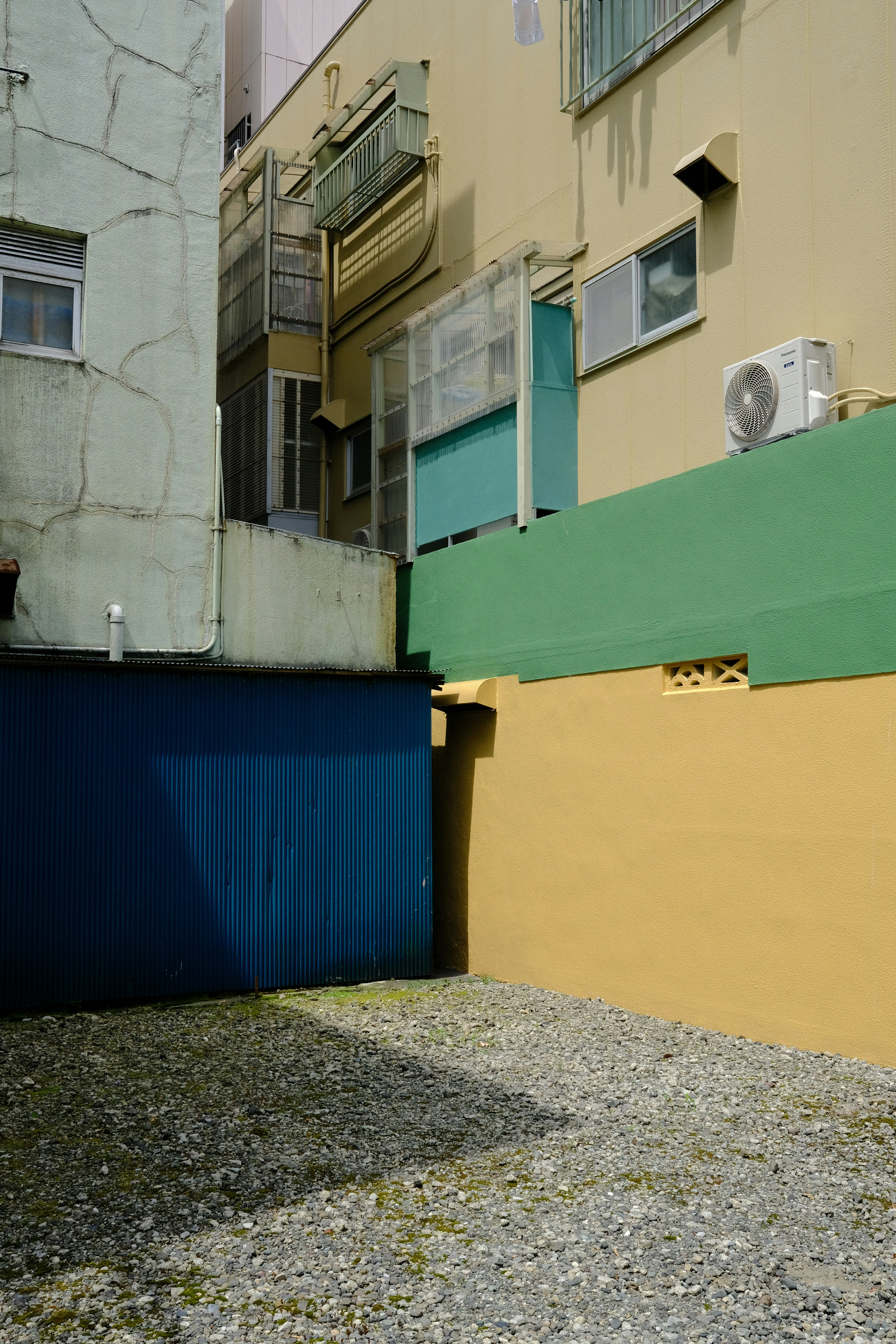 Coin urbain avec des murs colorés et un sol en gravier