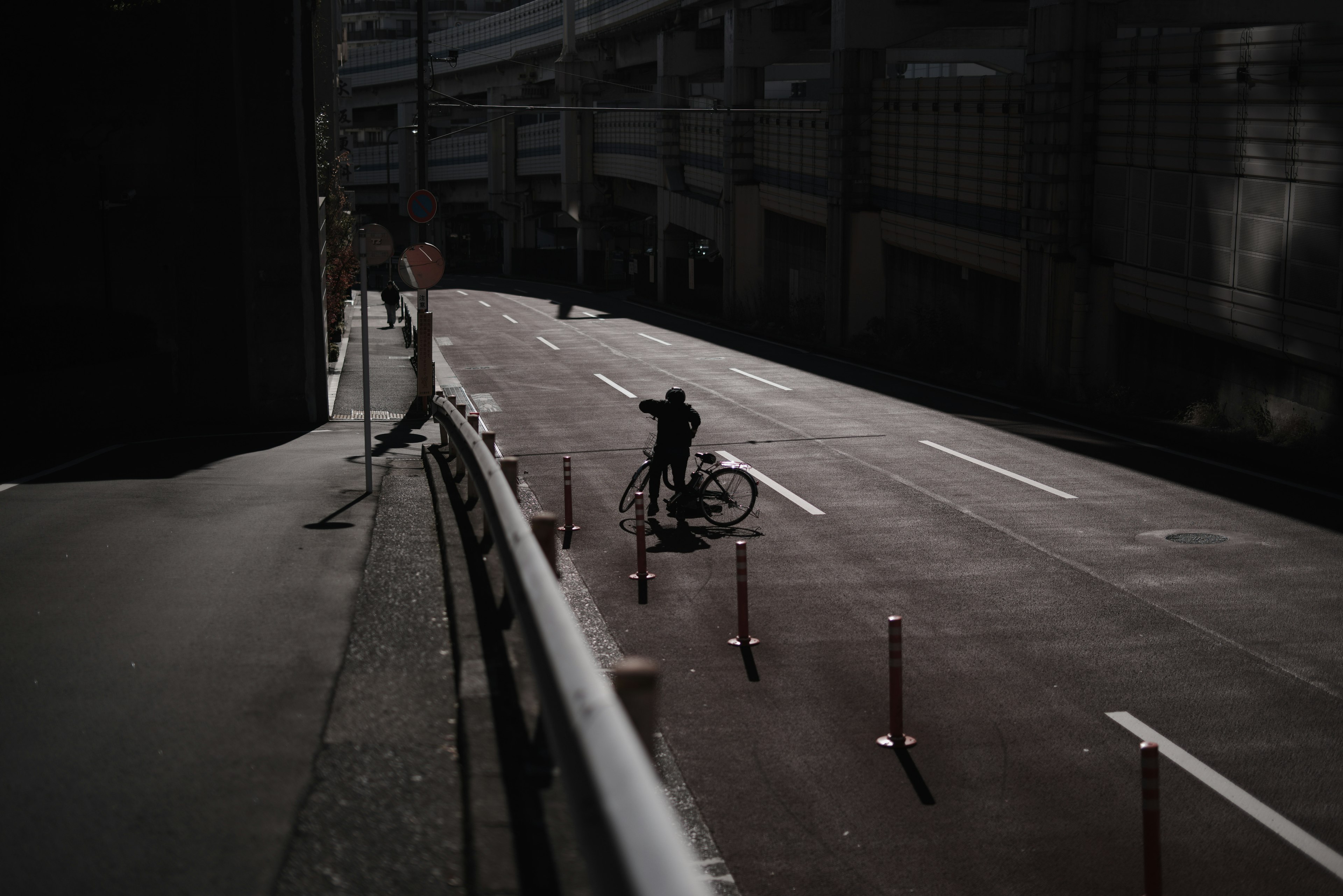 暗い道路で自転車に乗る人物と周囲の都市景観