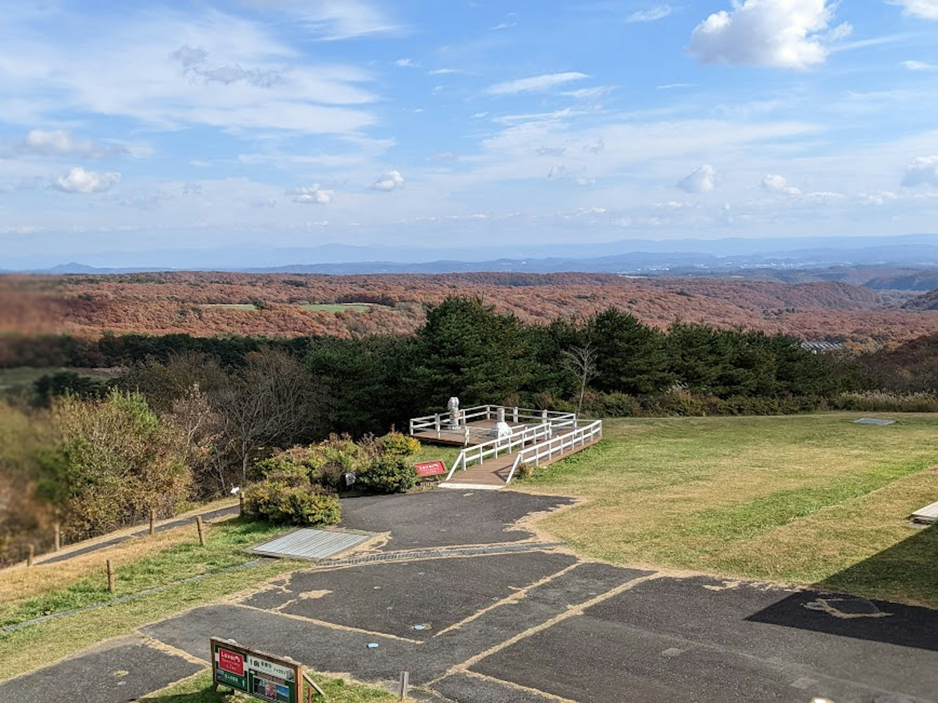 Vue panoramique avec une plateforme d'observation et de l'herbe verte sous un ciel bleu