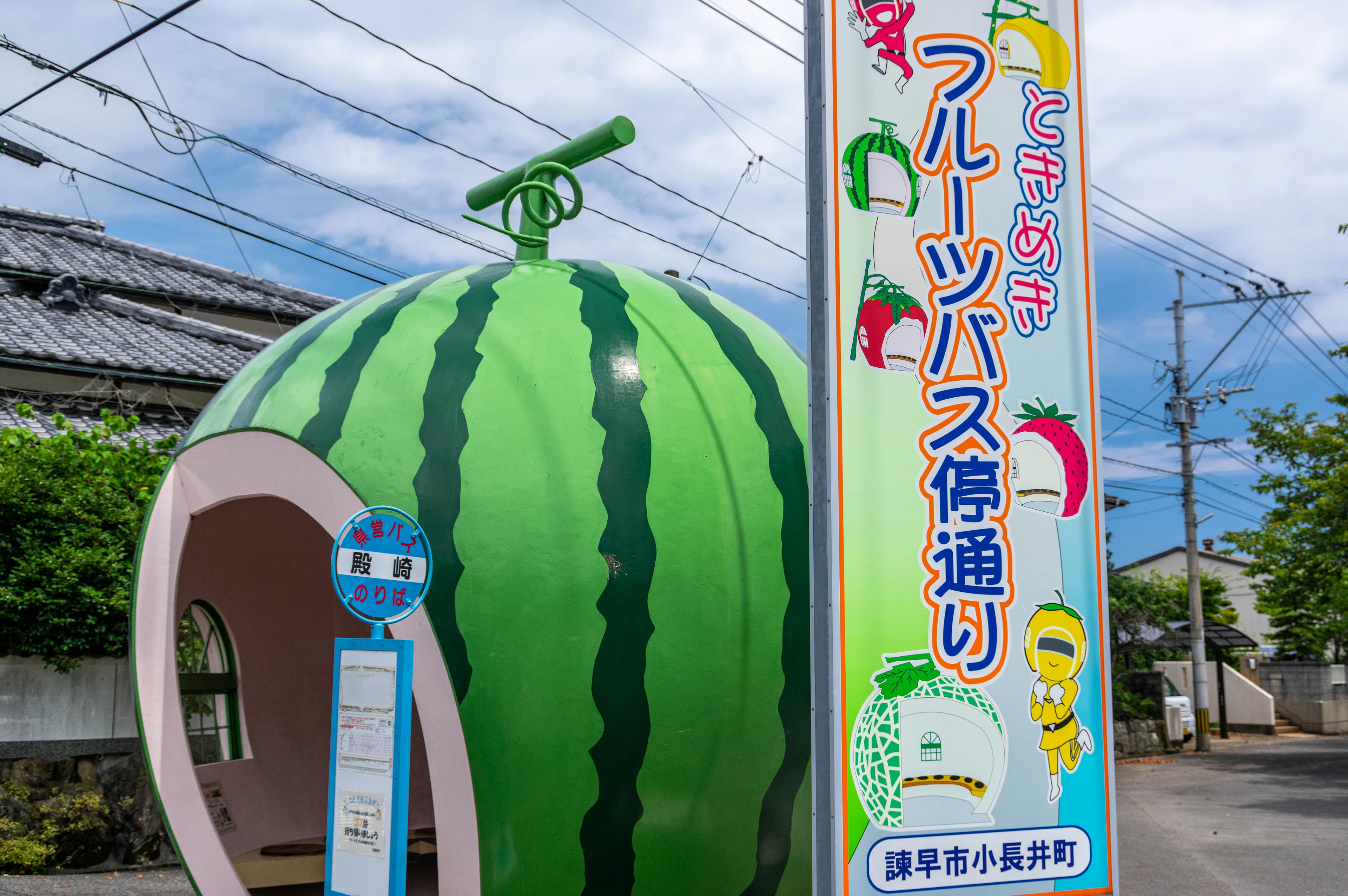 Watermelon-shaped bus stop with surrounding scenery