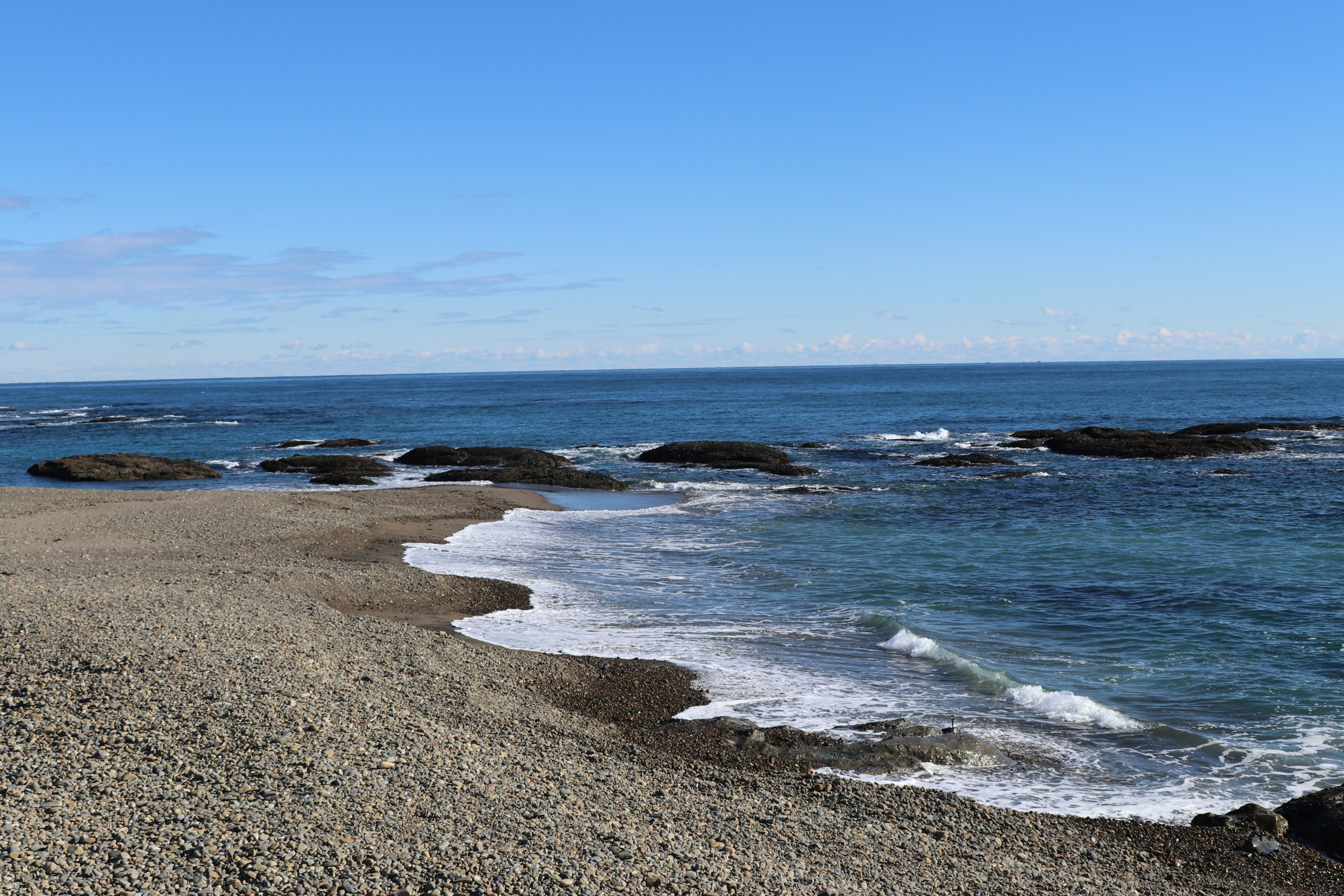 Scenic view of a rocky beach with blue ocean waves