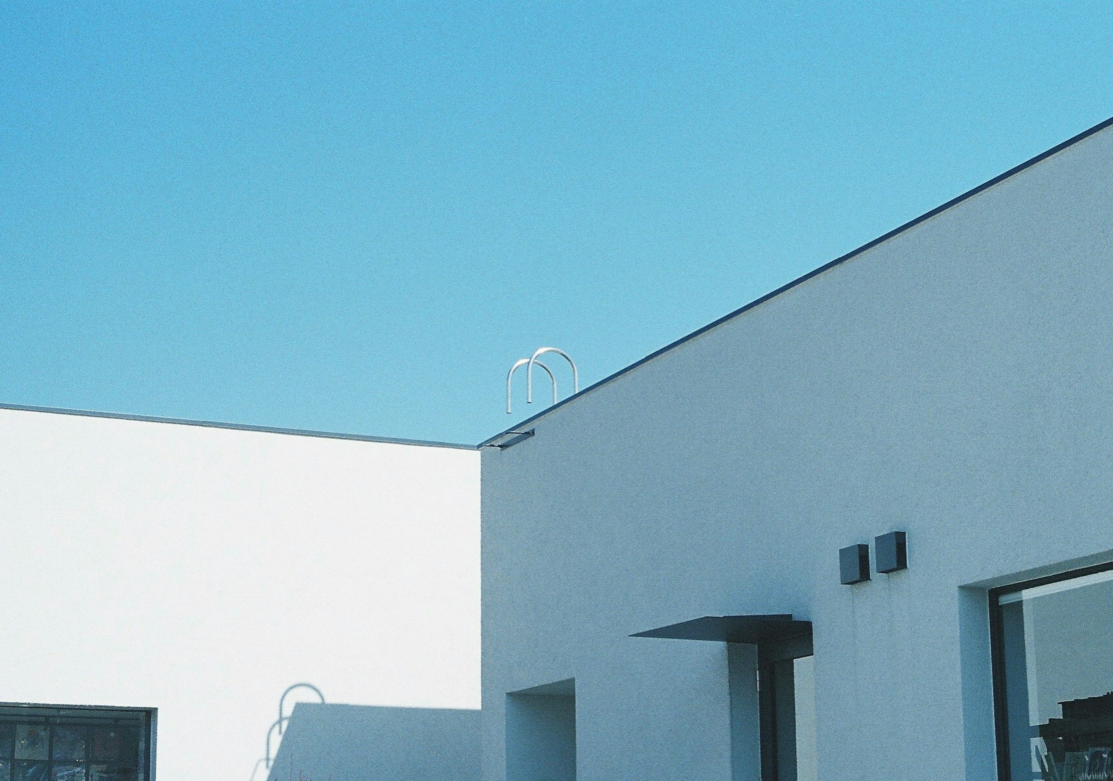 Teil eines weißen Gebäudes unter einem blauen Himmel