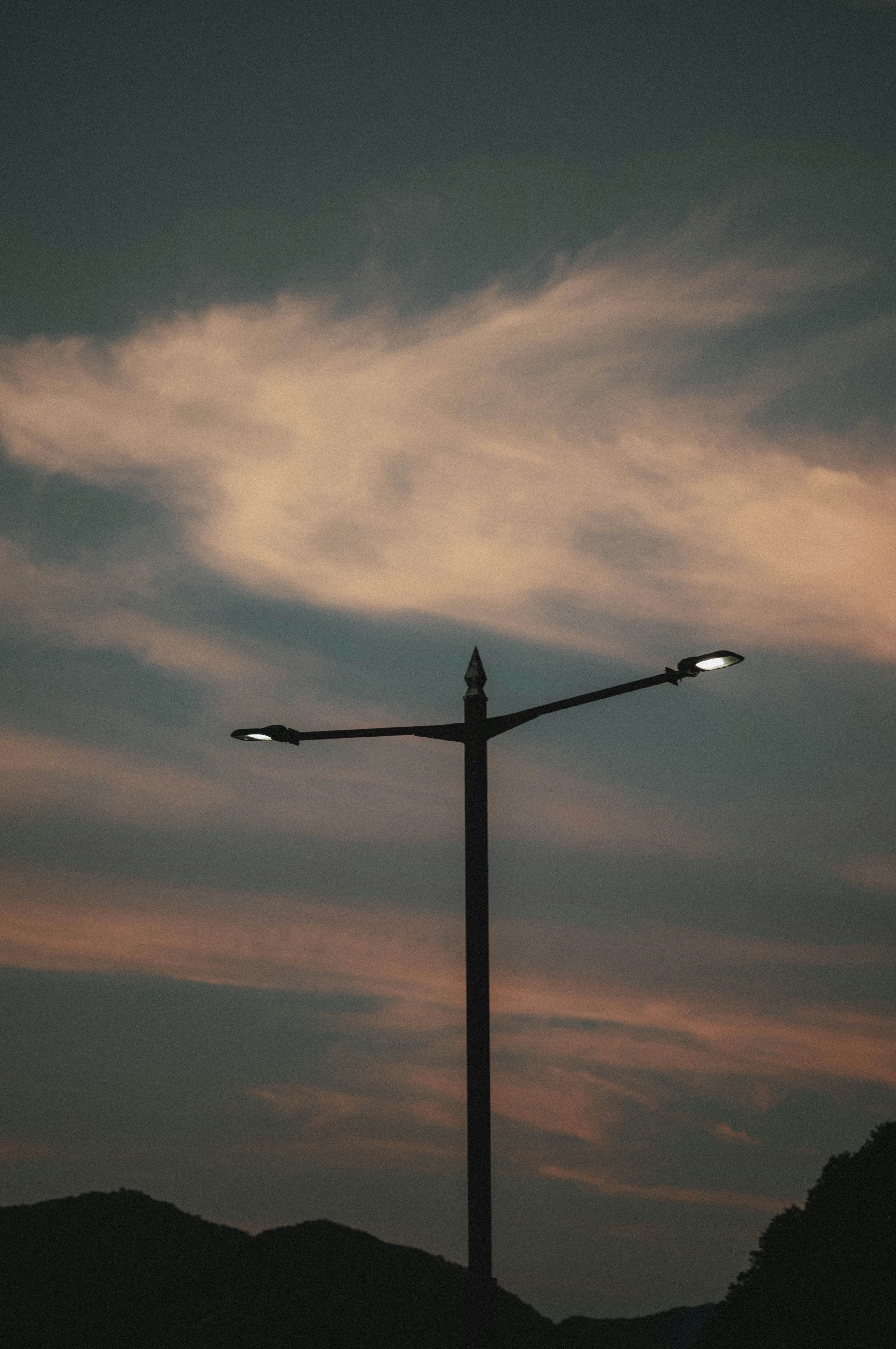 Straßenlaterne vor einem bunten Dämmerungshimmel silhouettiert