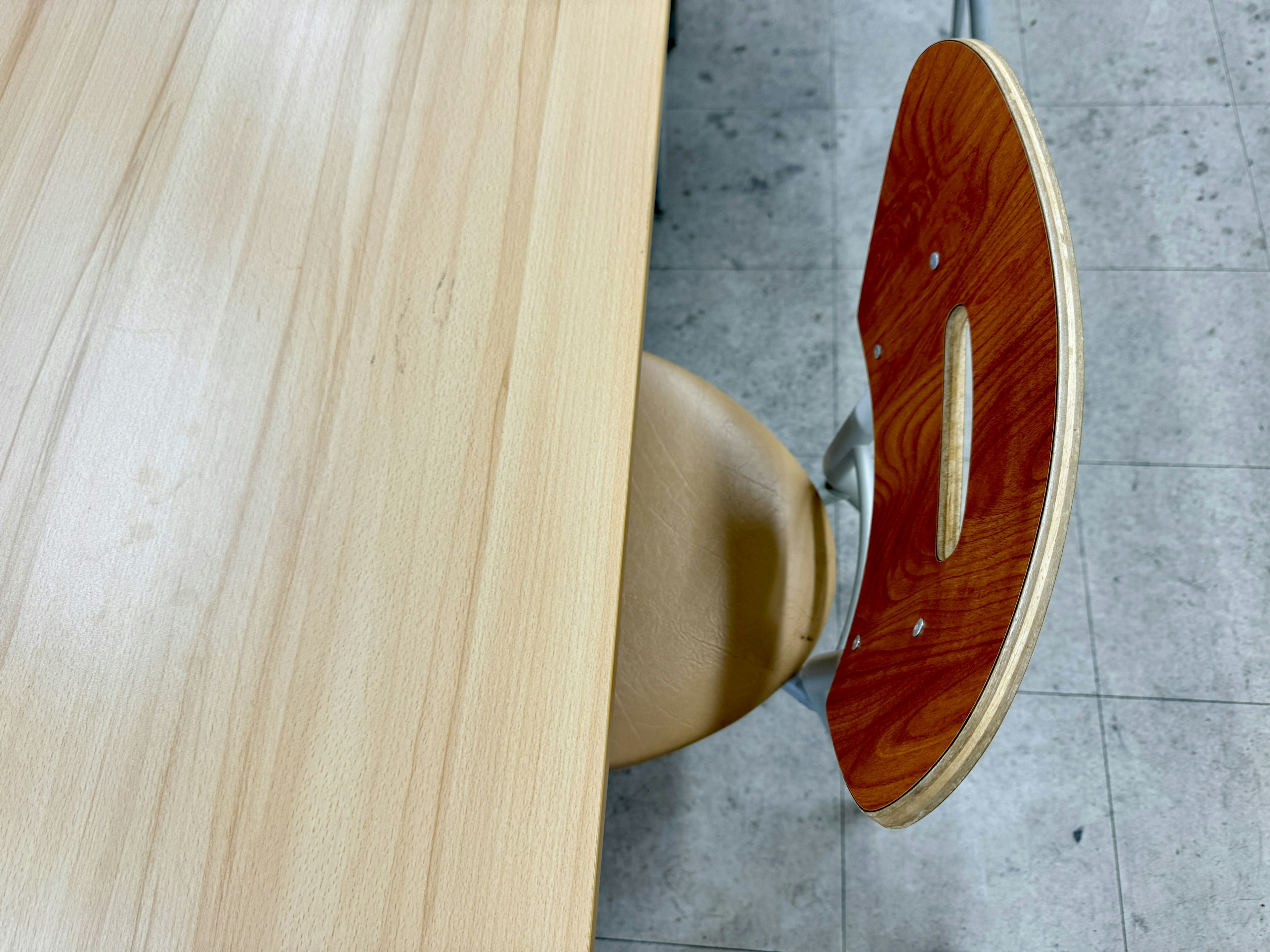 Partial view of a wooden table and a leather-covered chair