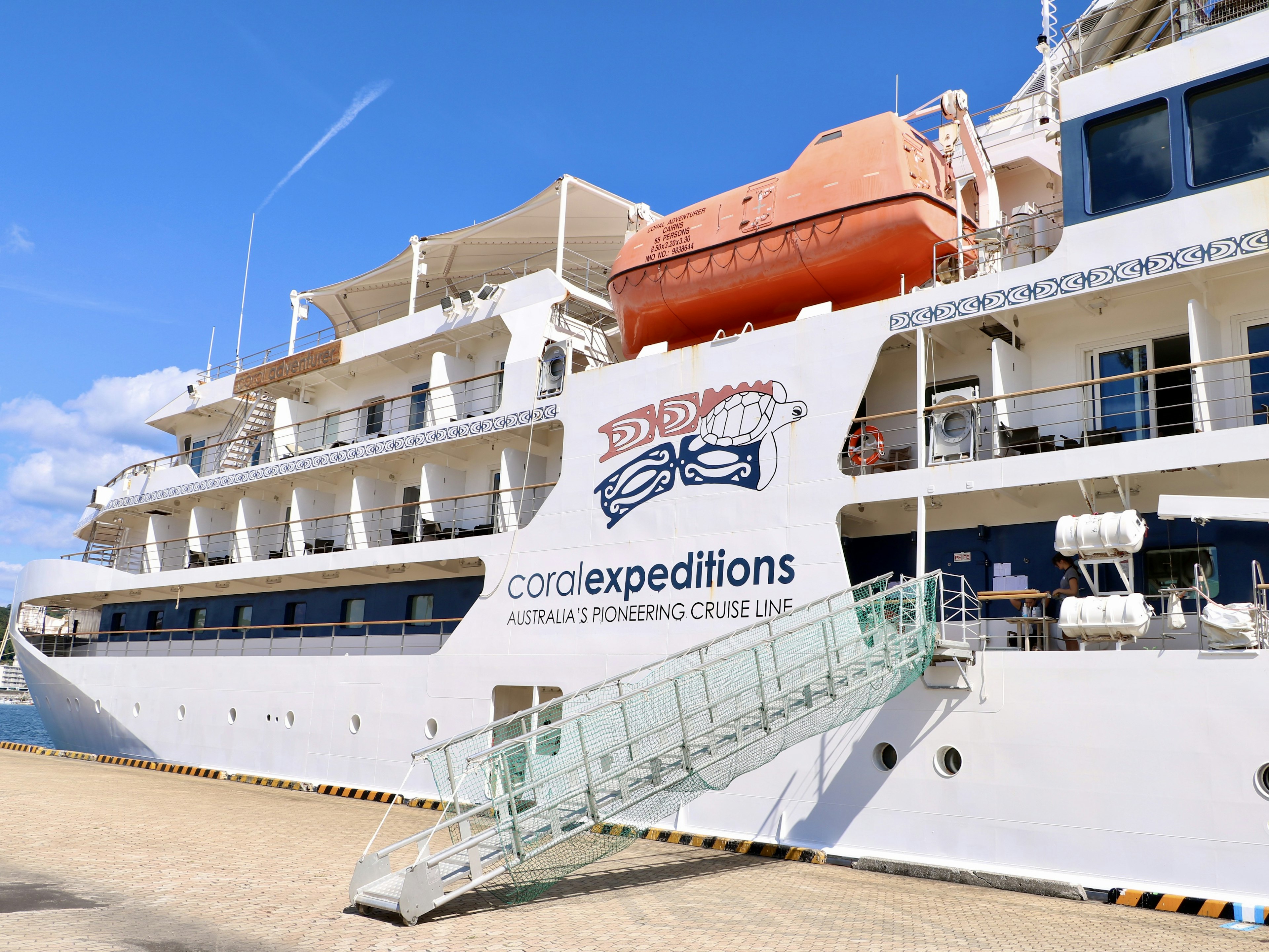 Side view of a luxury cruise ship with a visible gangway