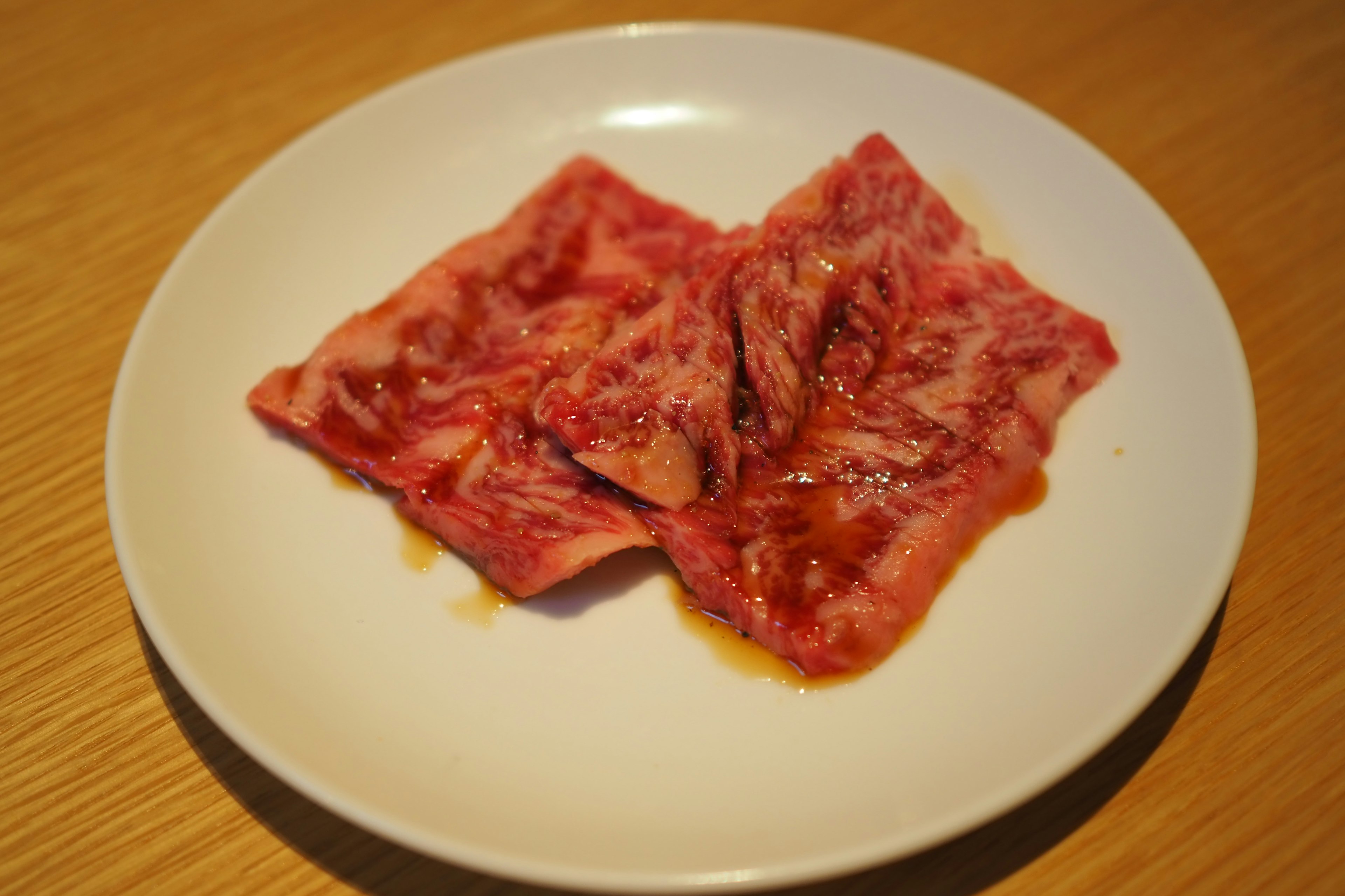 Slices of marinated meat on a white plate