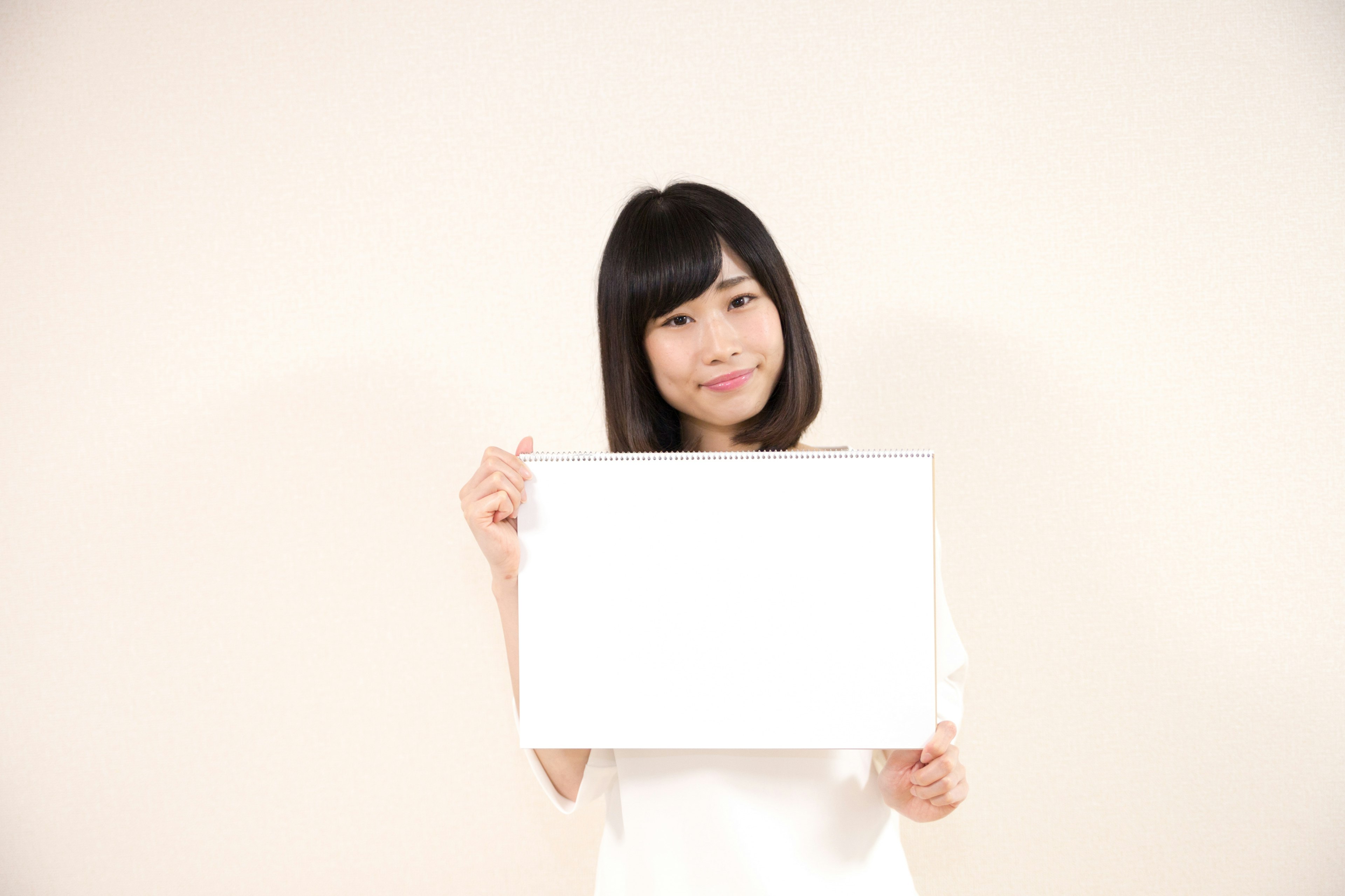 A woman holding a blank sign in front of a white background