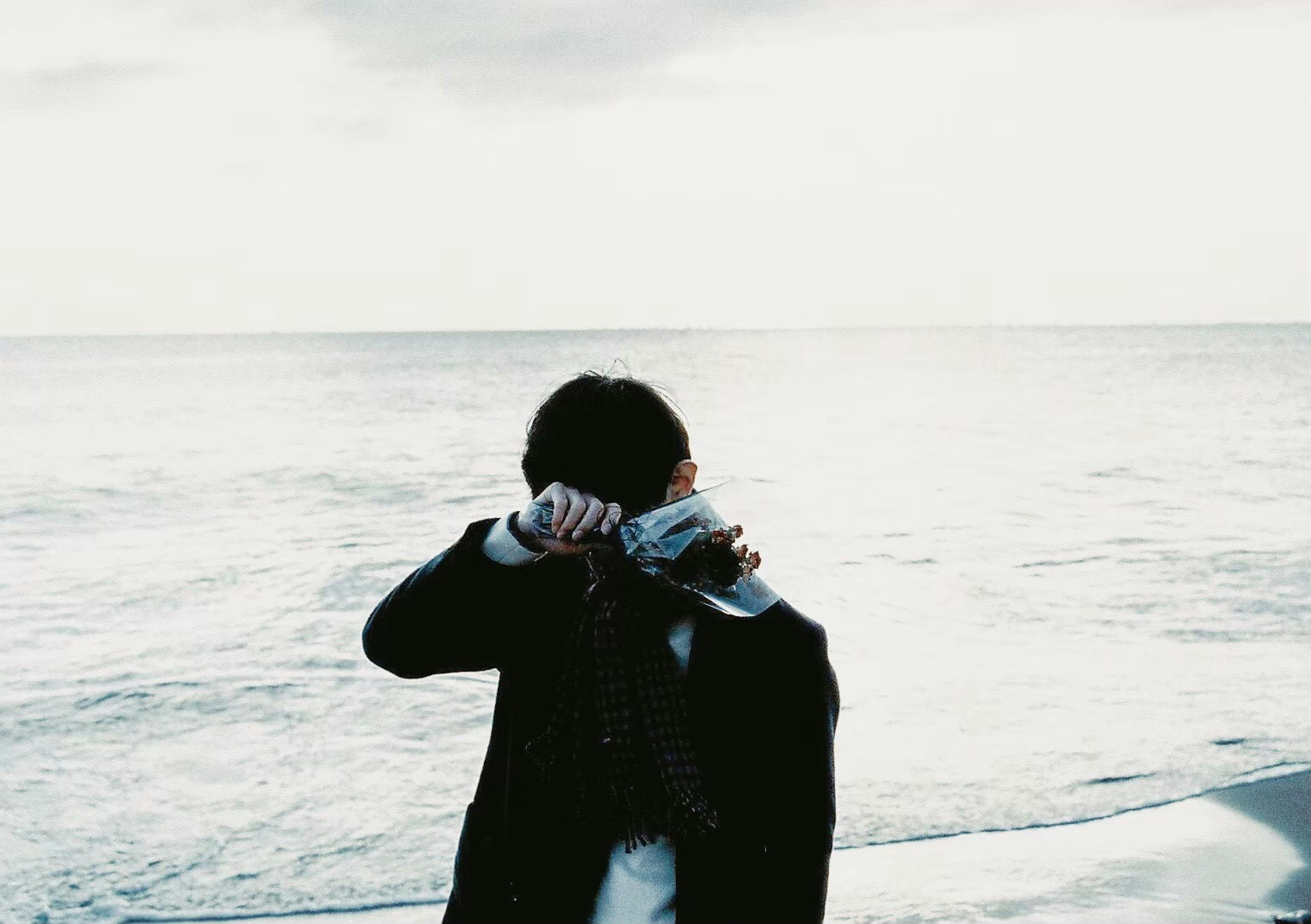 Silhouette d'une personne tenant un appareil photo au bord de la mer