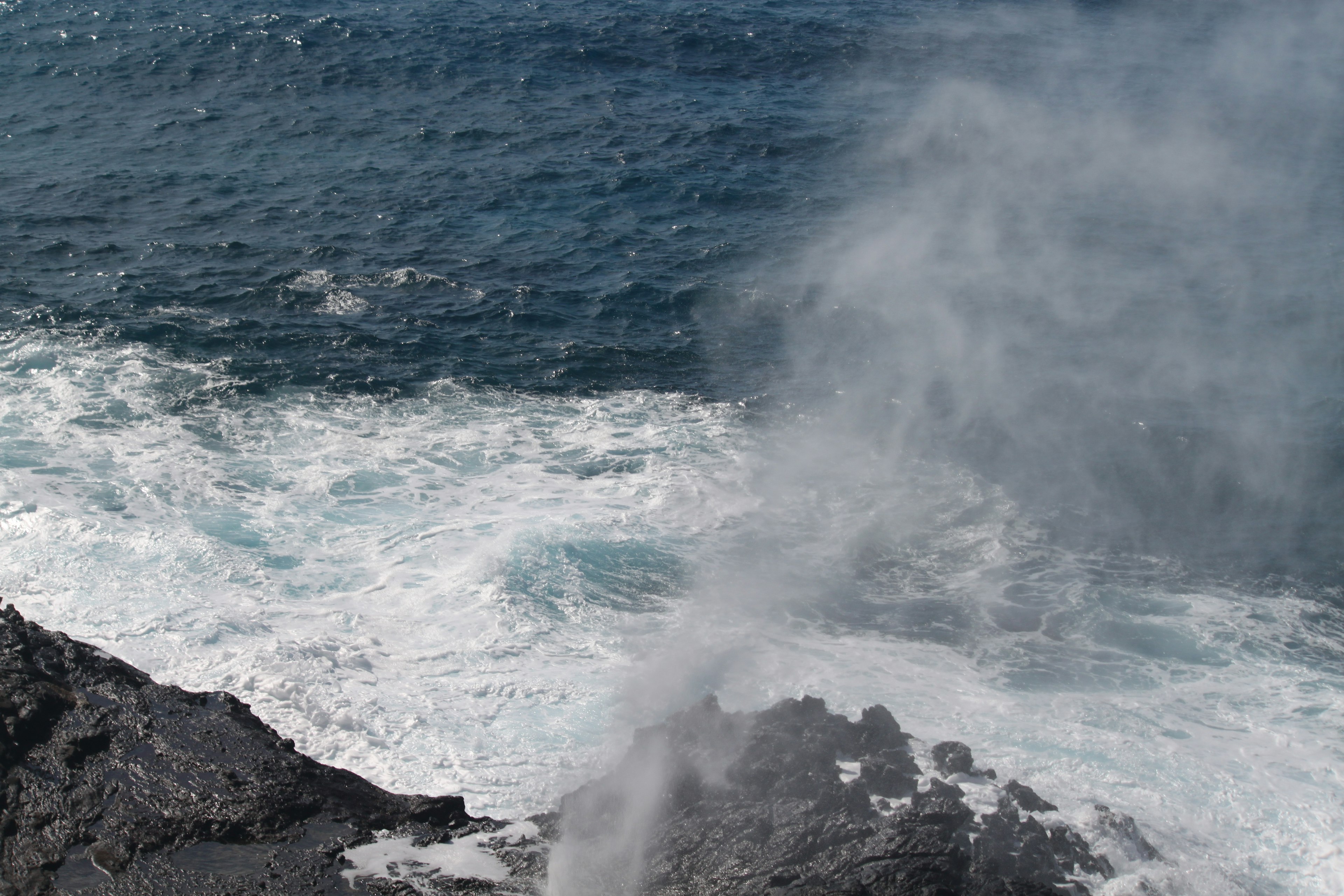 海の波が岩に打ち寄せる風景と水しぶき