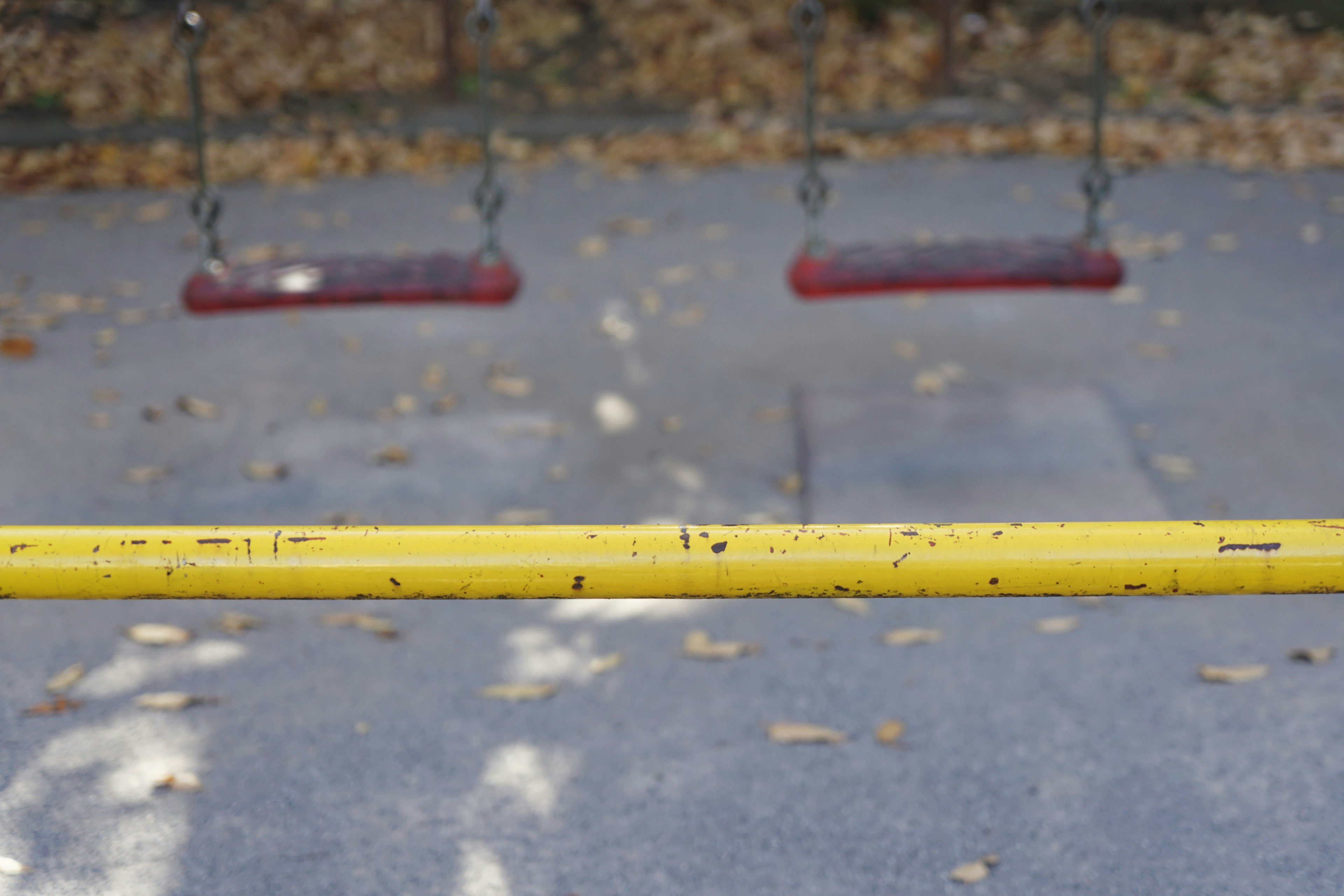 Una barra gialla con altalene rosse in un parco