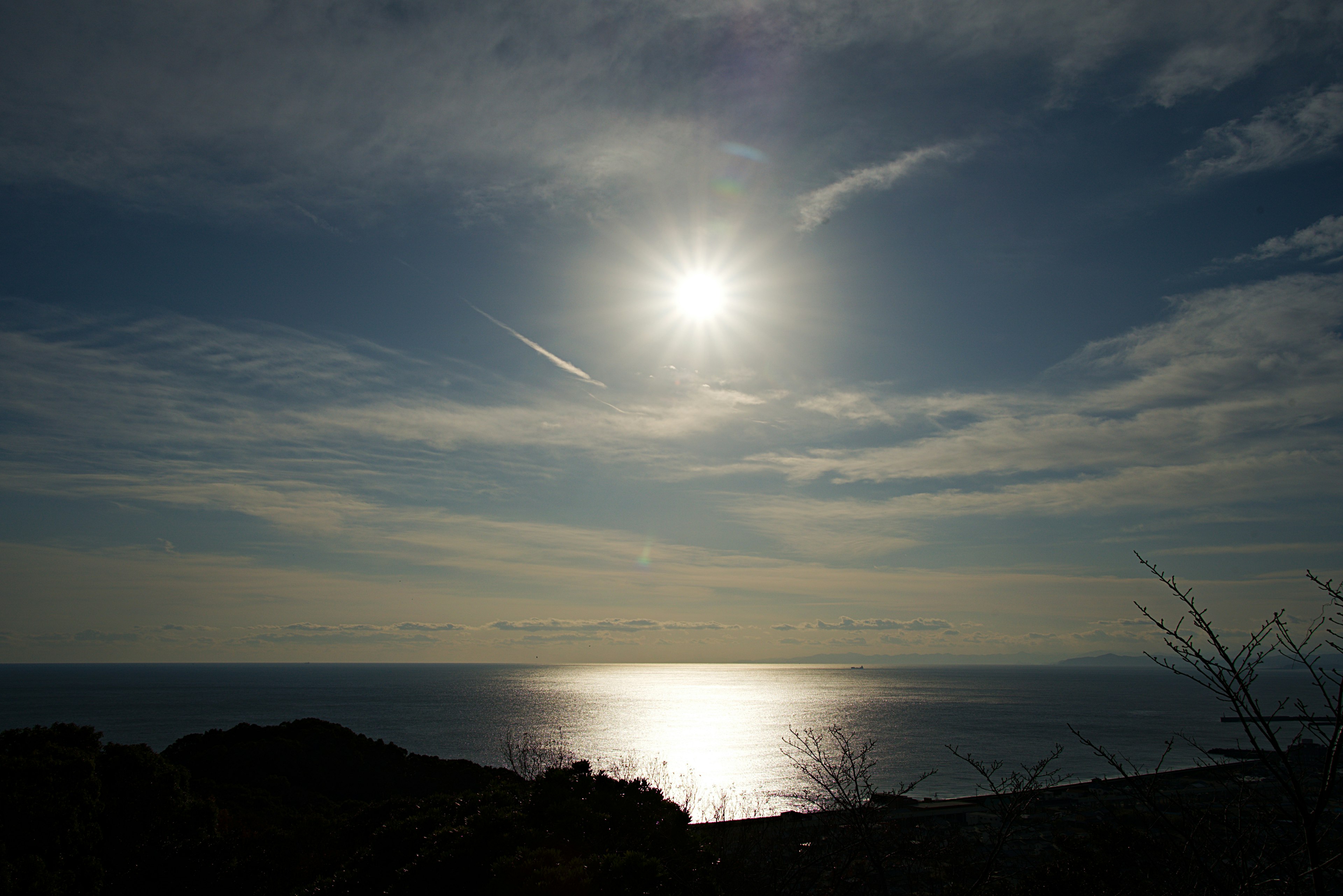 Vista panoramica del sole che brilla su un mare calmo e un cielo nuvoloso