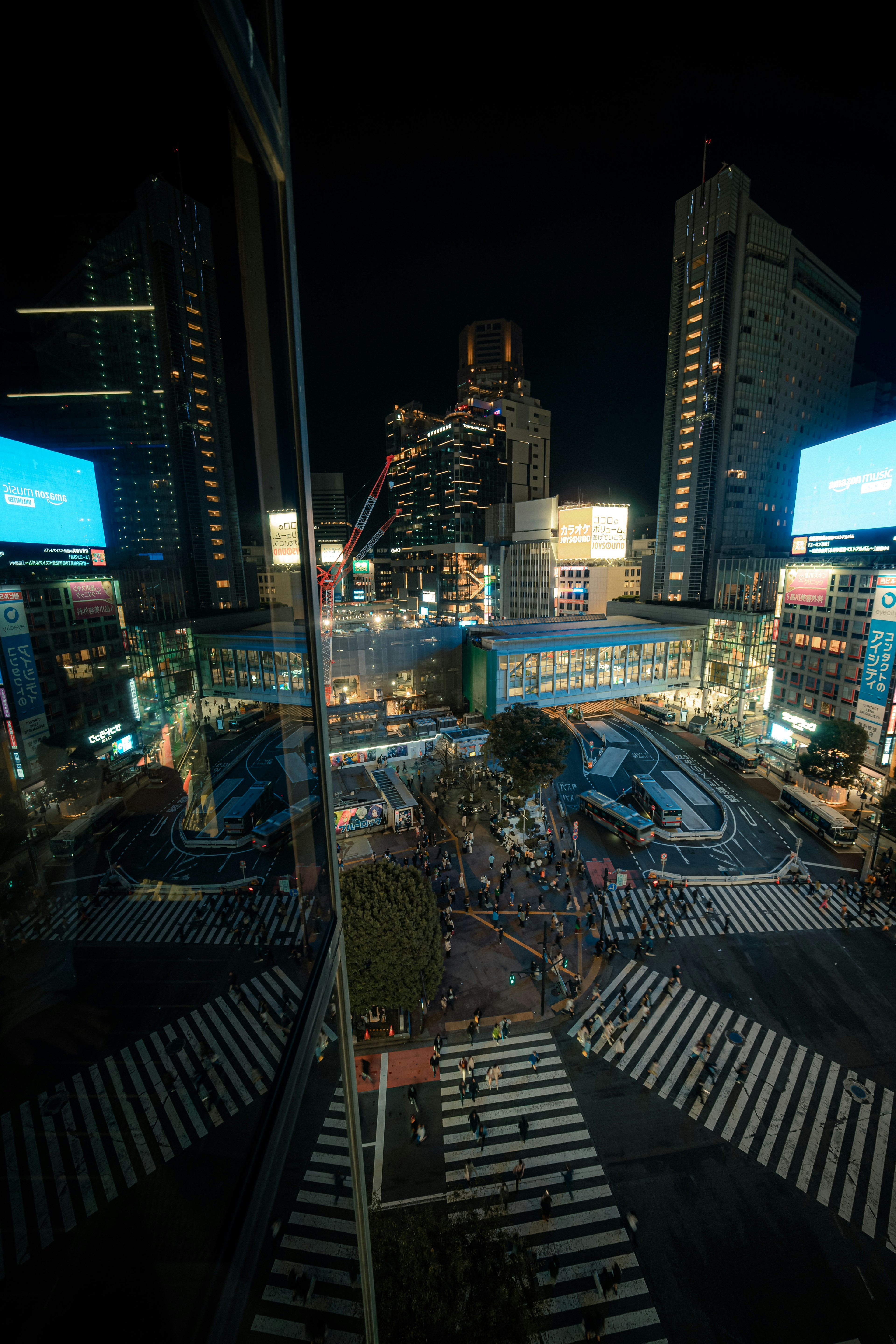 Vue d'ensemble du carrefour de Shibuya la nuit avec des bâtiments et des écrans numériques