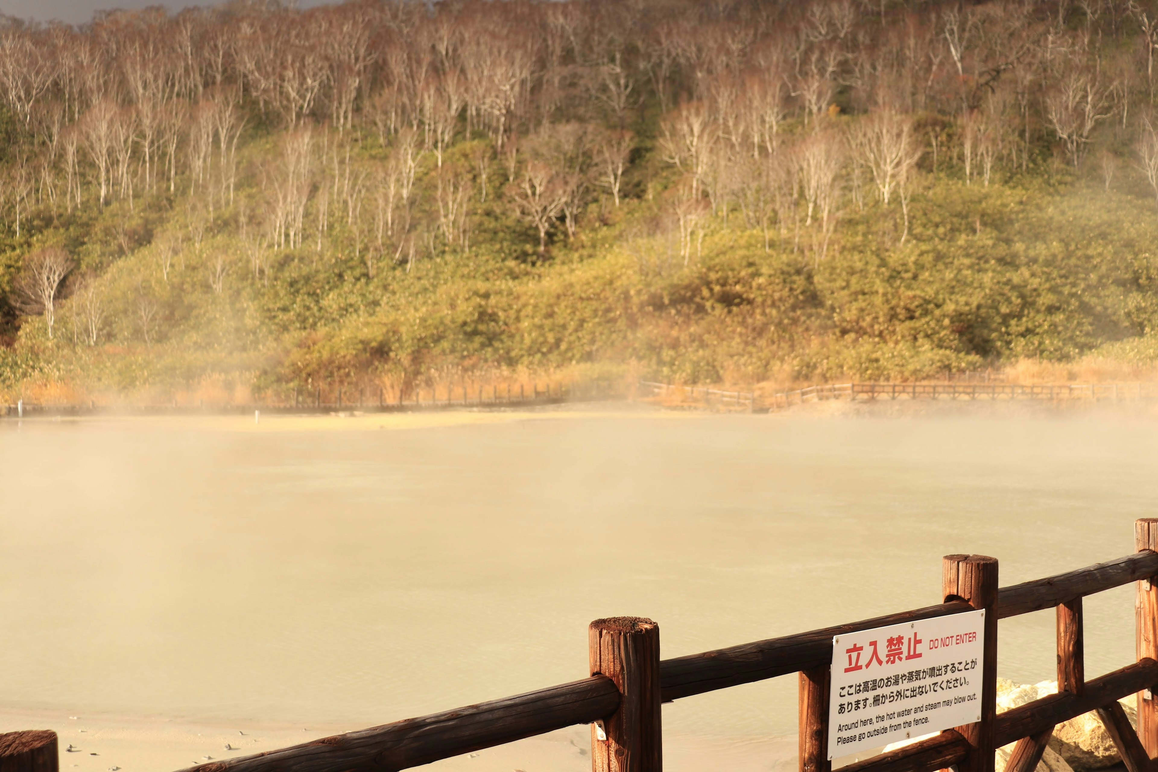 Vista serena di un lago con vapore che sale dalle sorgenti termali