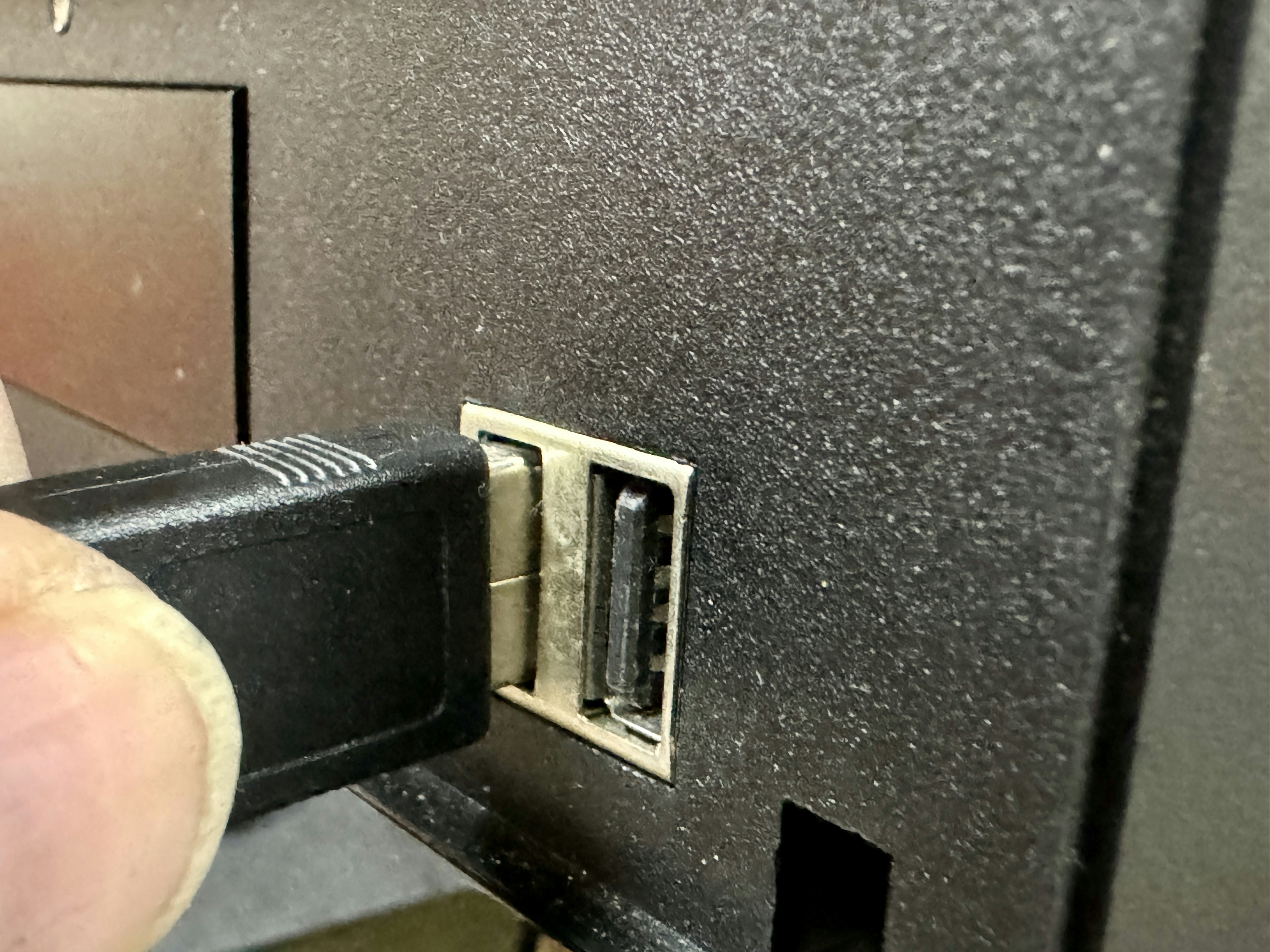 A USB connector being plugged into a computer USB port