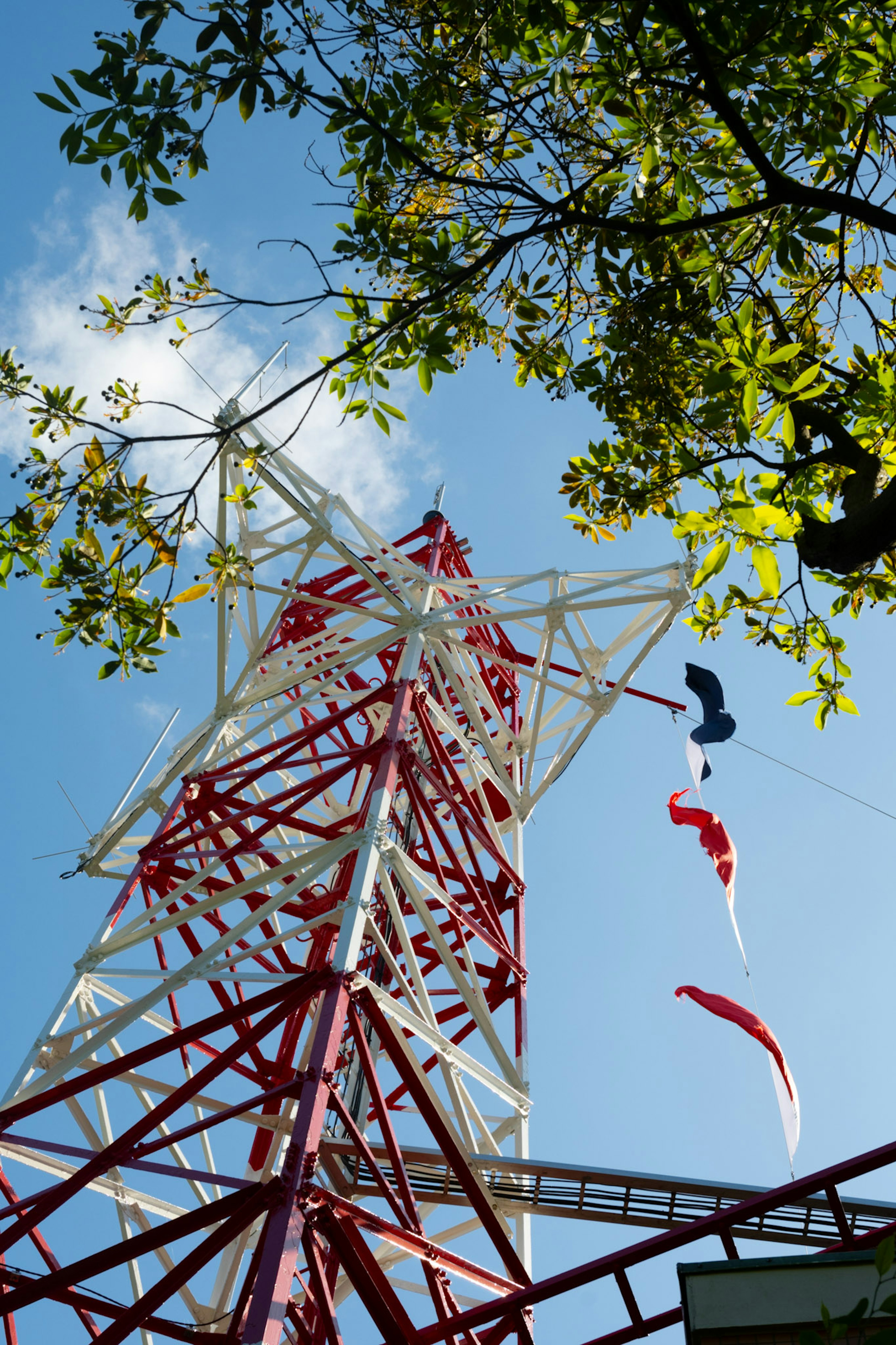 Torre di comunicazione rossa e bianca con paracadute contro un cielo blu