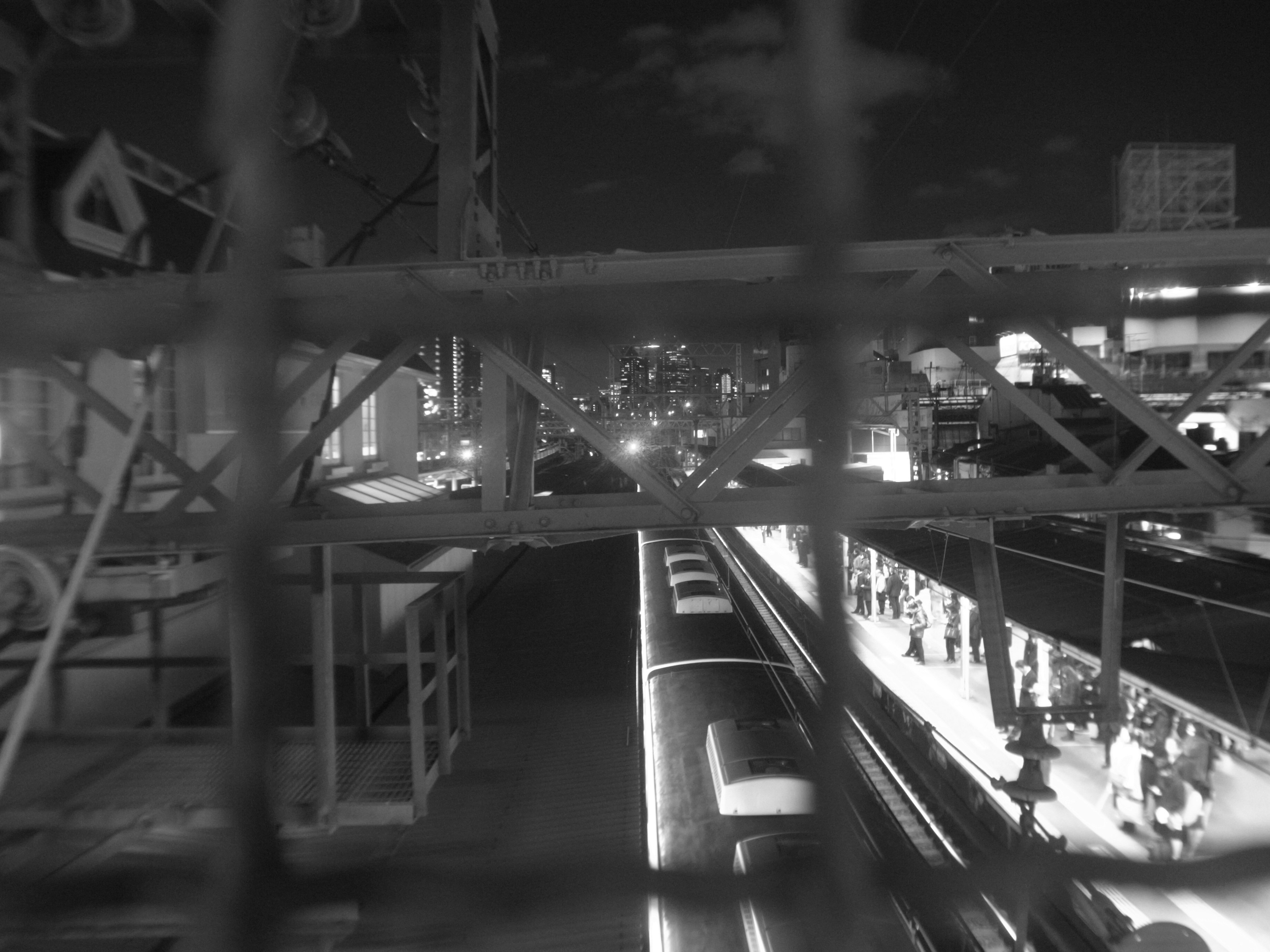 Black and white night cityscape featuring a train station and train