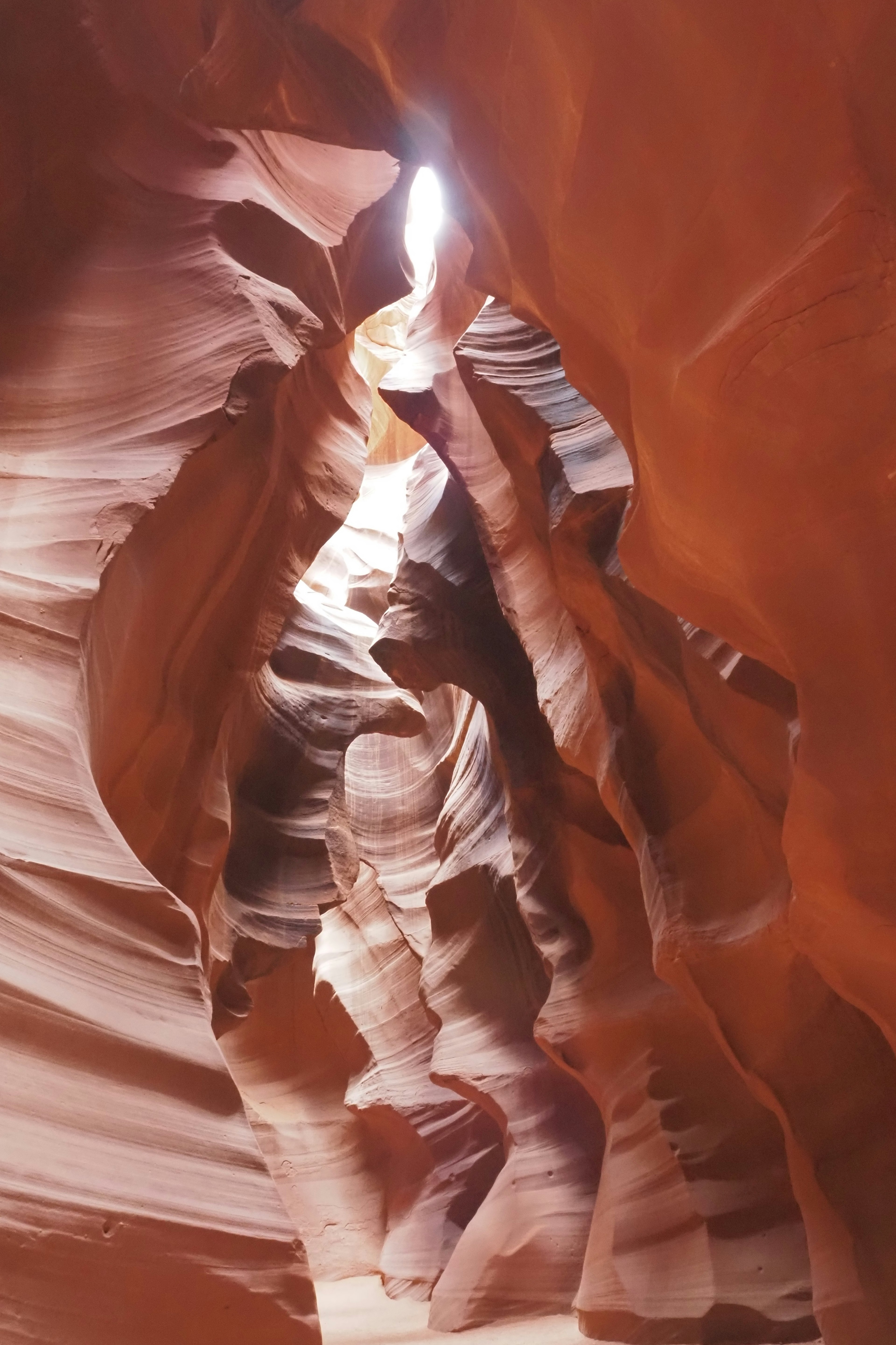 Interior view of Antelope Canyon with smooth red rock formations and light streaming through narrow openings