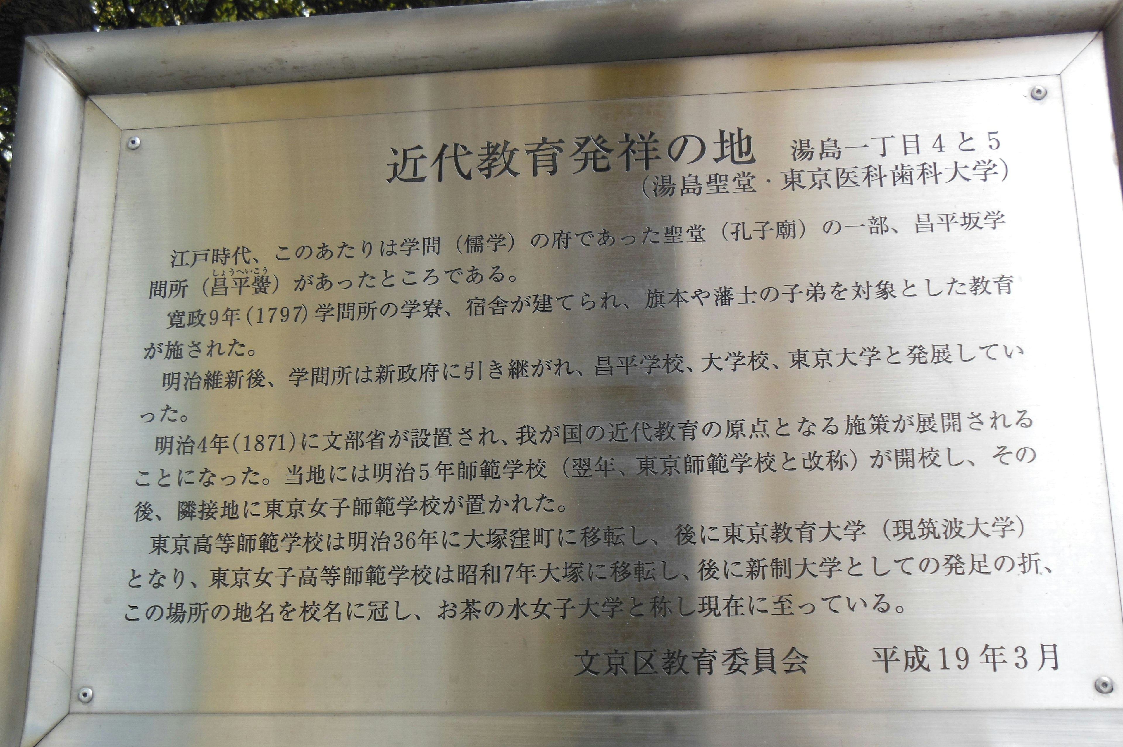 Placa que marca el lugar de nacimiento de la educación moderna Superficie de metal plateado Texto en japonés