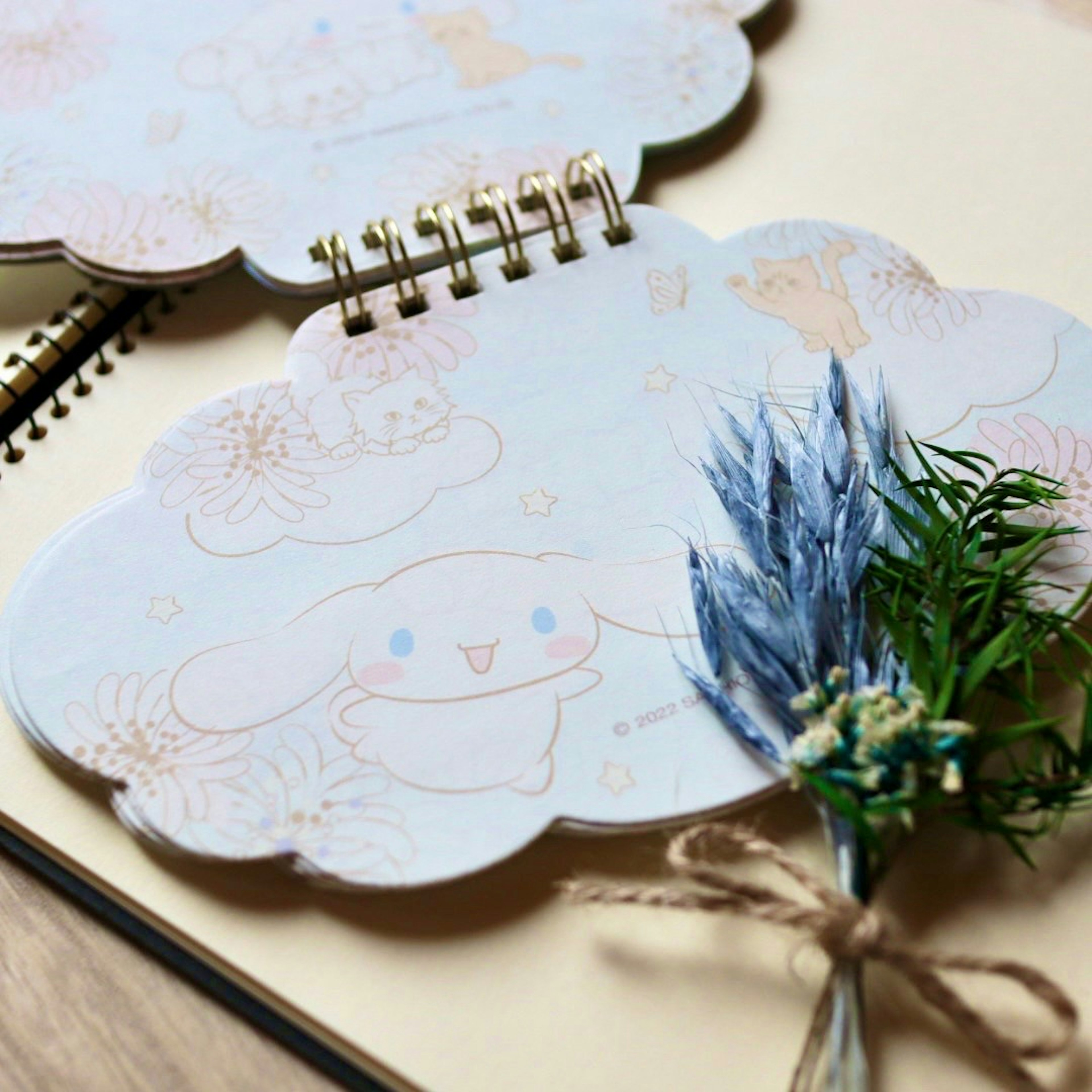 Un carino quaderno e un blocco note decorati con un fiore blu e un nastro