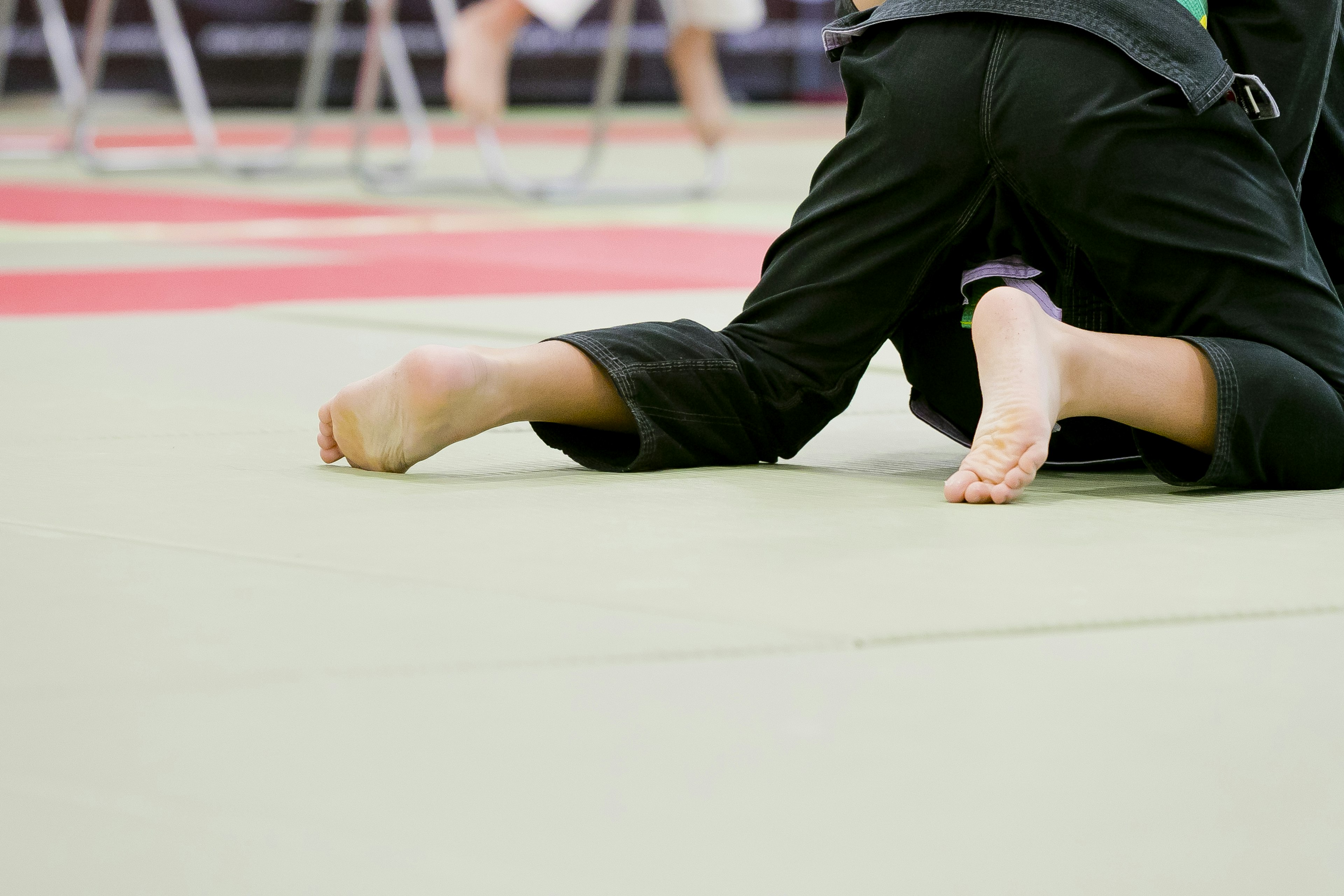 Pies de un niño y parte del cuerpo en un tatami de judo