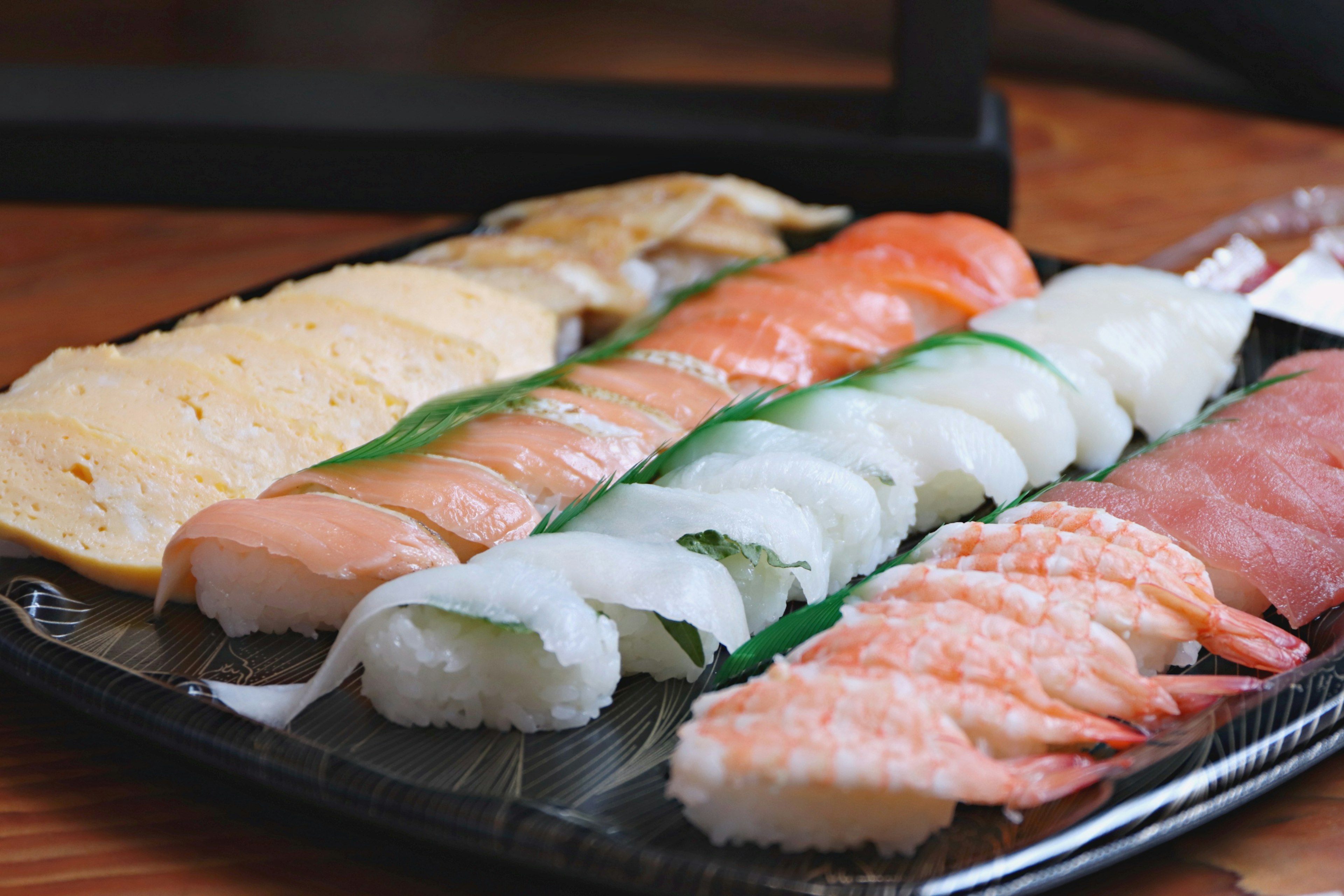 An assortment of sushi arranged on a black platter