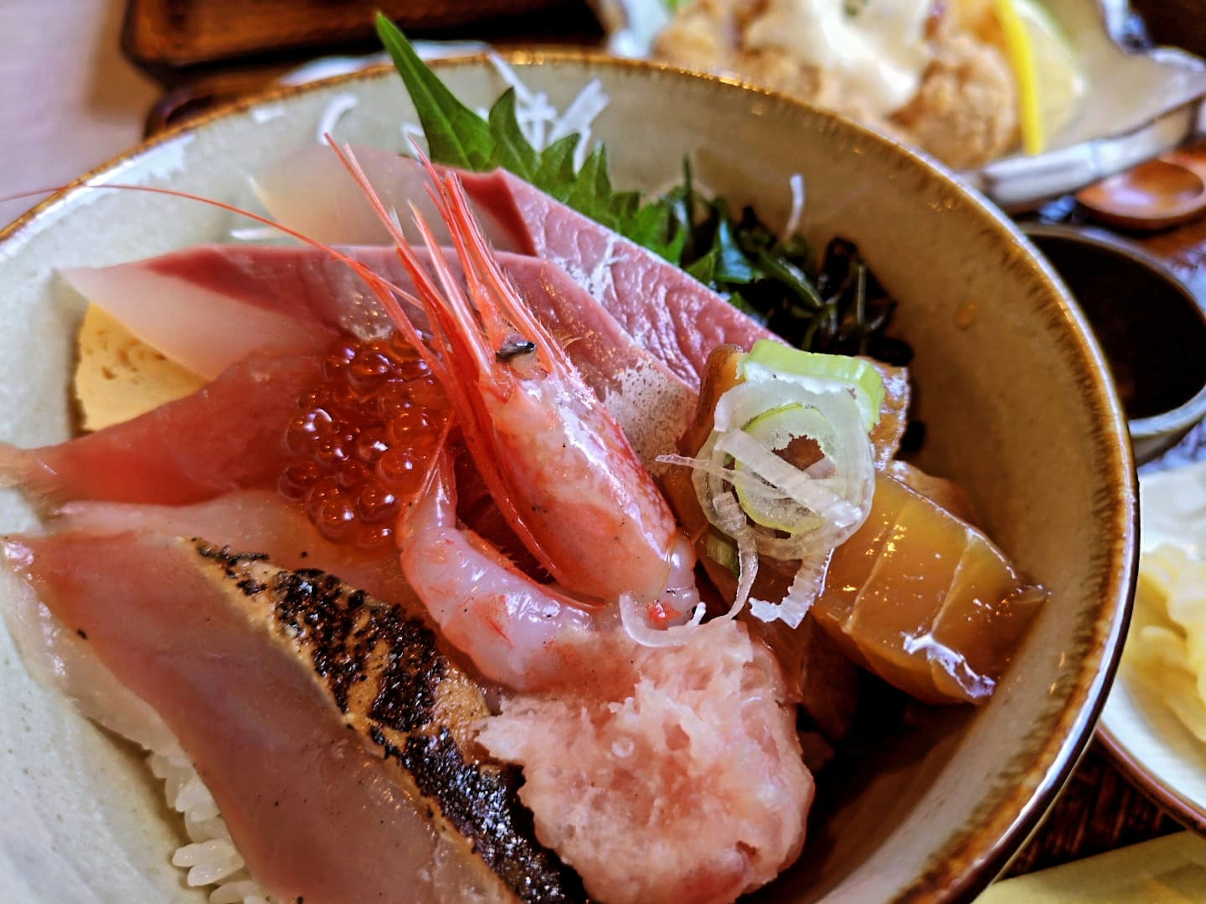 新鮮な刺身とご飯が盛り付けられた海鮮丼の画像