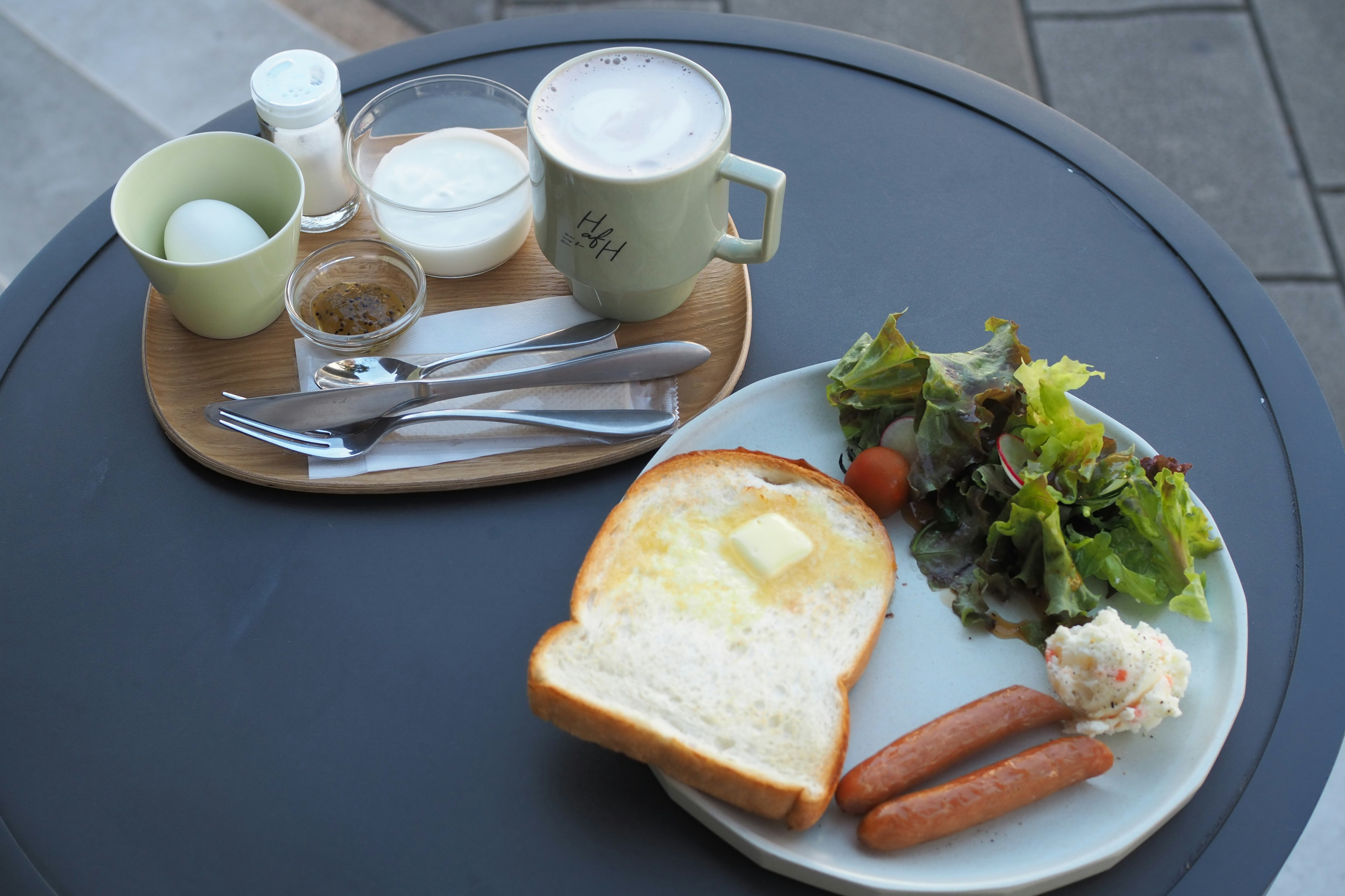 Breakfast plate featuring toast, sausages, and fresh salad